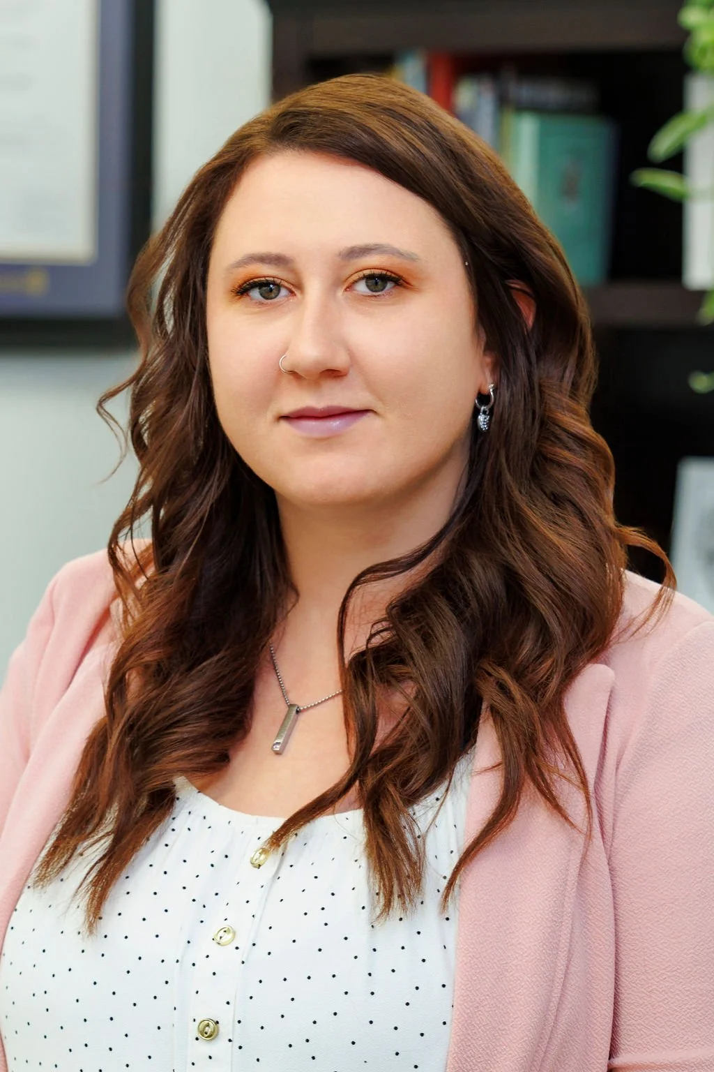 This is a picture of Kayla. She is wearing a pink blazer. She is smiling.