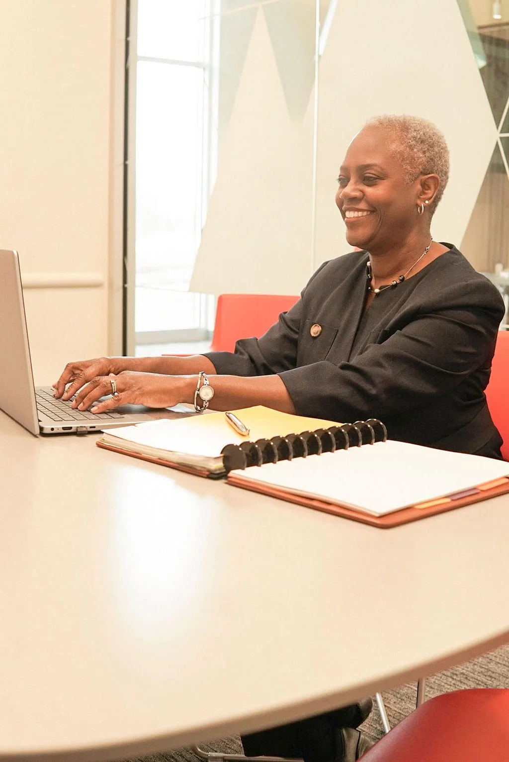 Grant proposal writing consultant working at laptop during nonprofit funding strategy session
