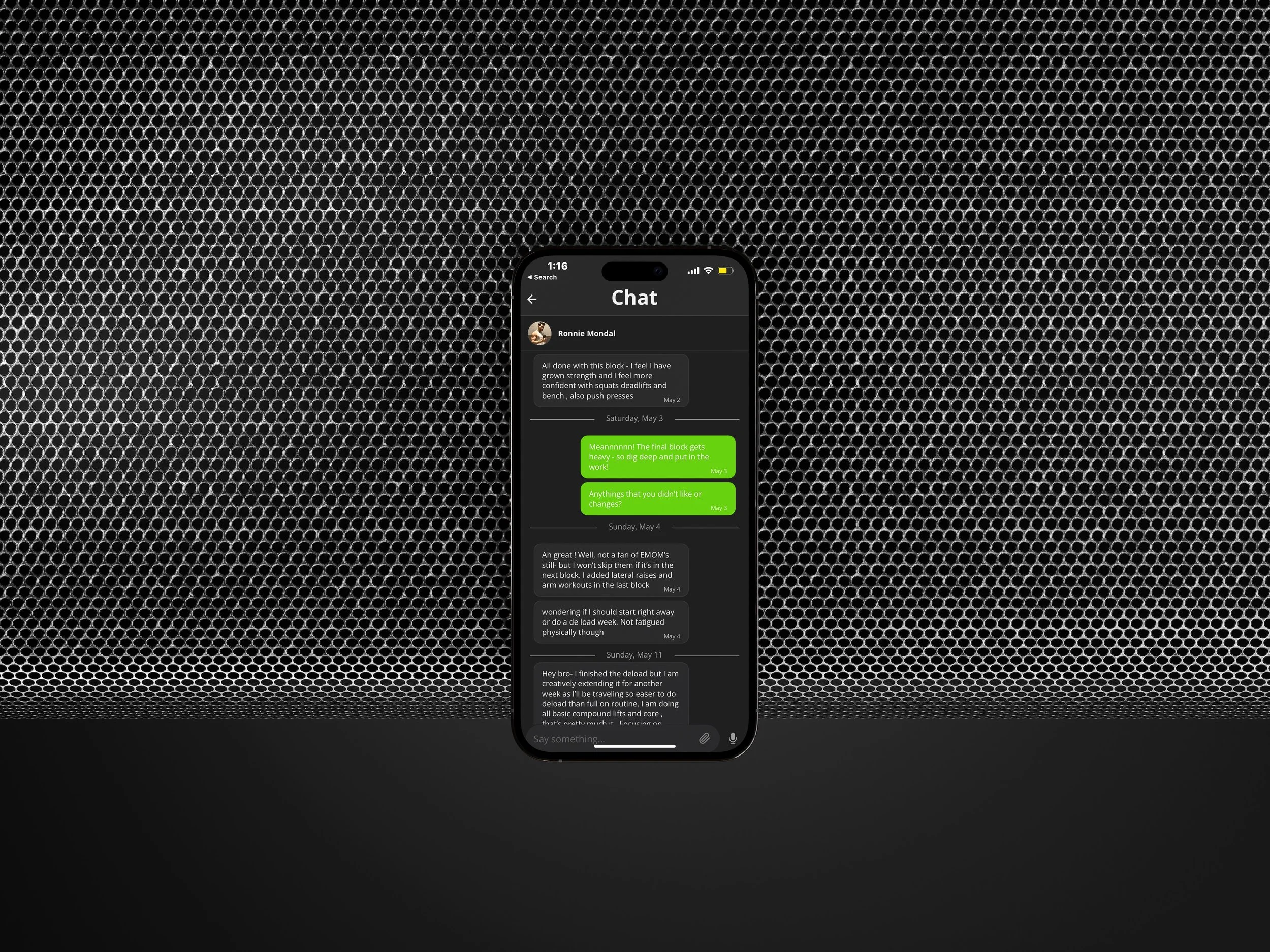 Smartphone displaying a chat conversation with various messages, set against a black textured background.