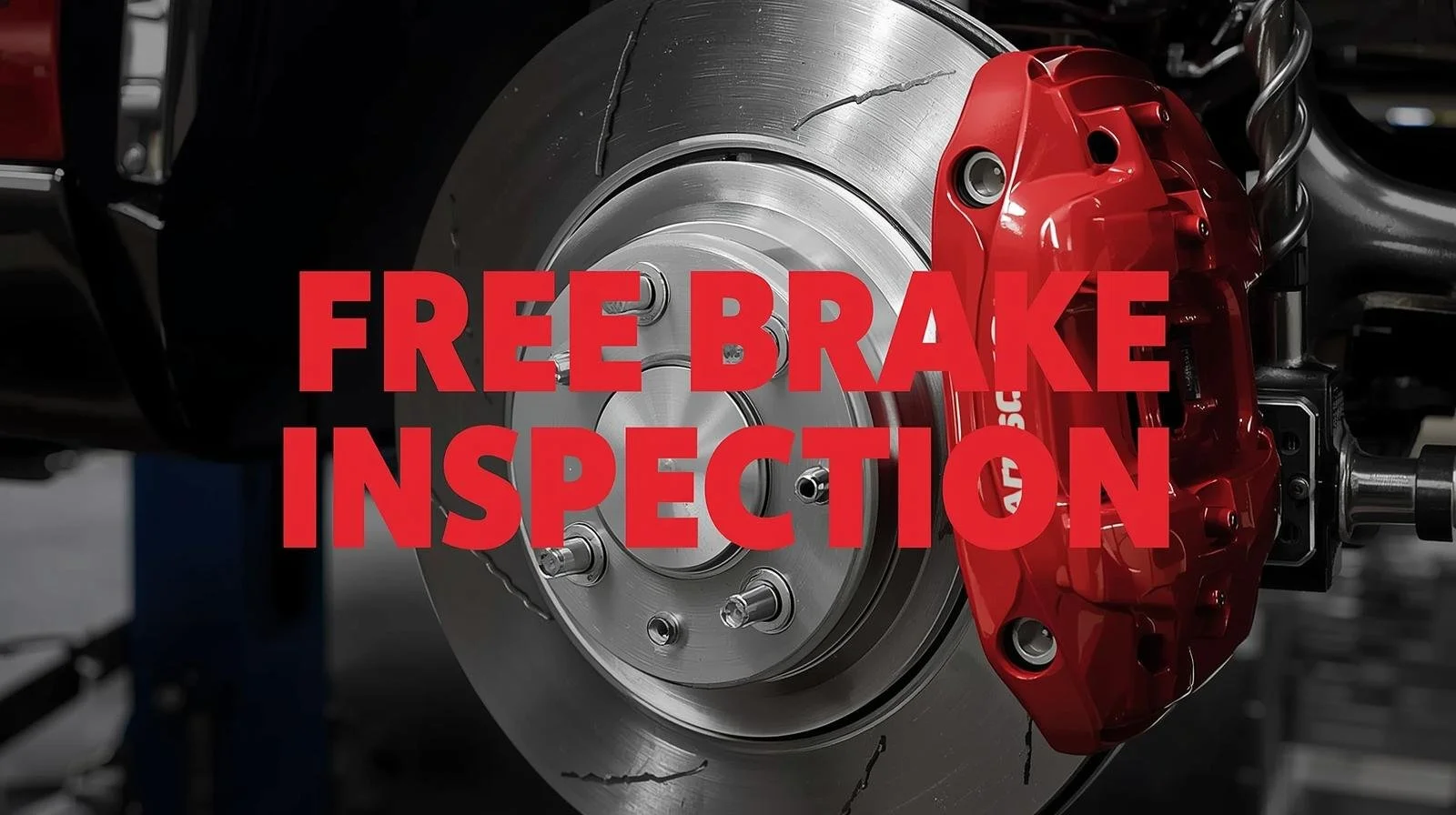 Close-up of a car brake disc with a red brake caliper, with the text 'Free Brake Inspection' overlayed in red