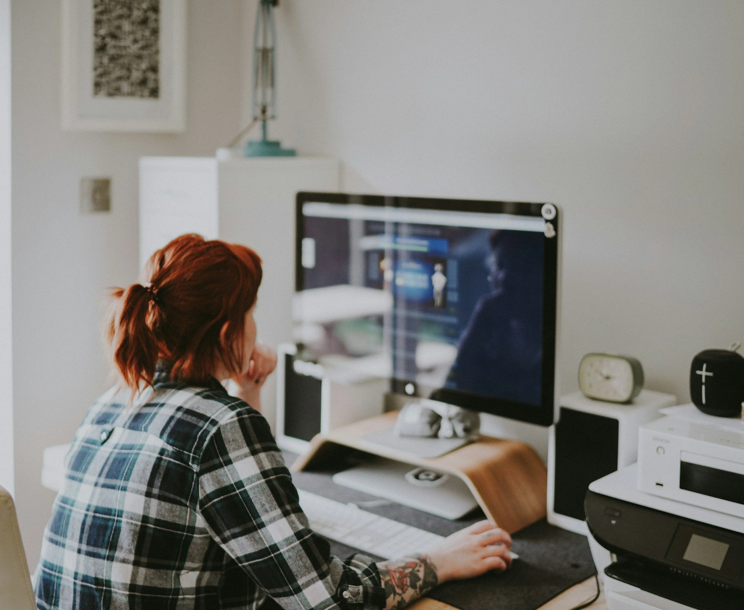 woman wearing a plaid shirt working from home on her computer