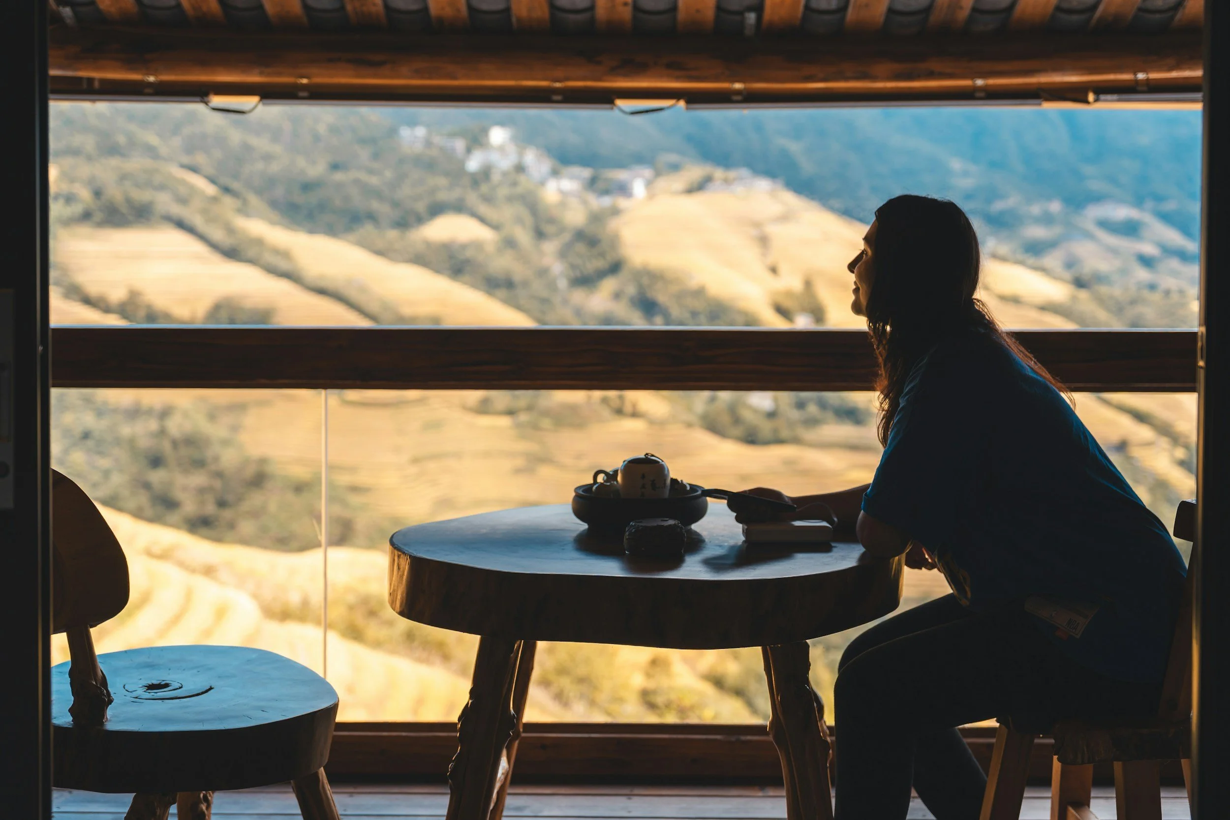 A quiet moment with tea and a notebook on a veranda overlooking the hills