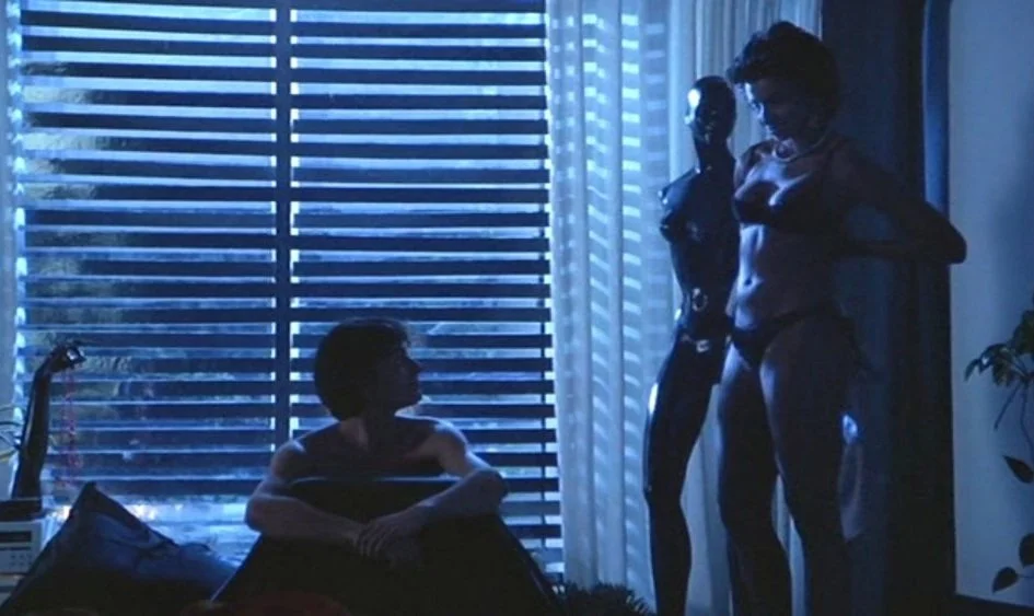 diva-1981-001-woman-undressing-by-dummy-over-man-in-bed.jpg
