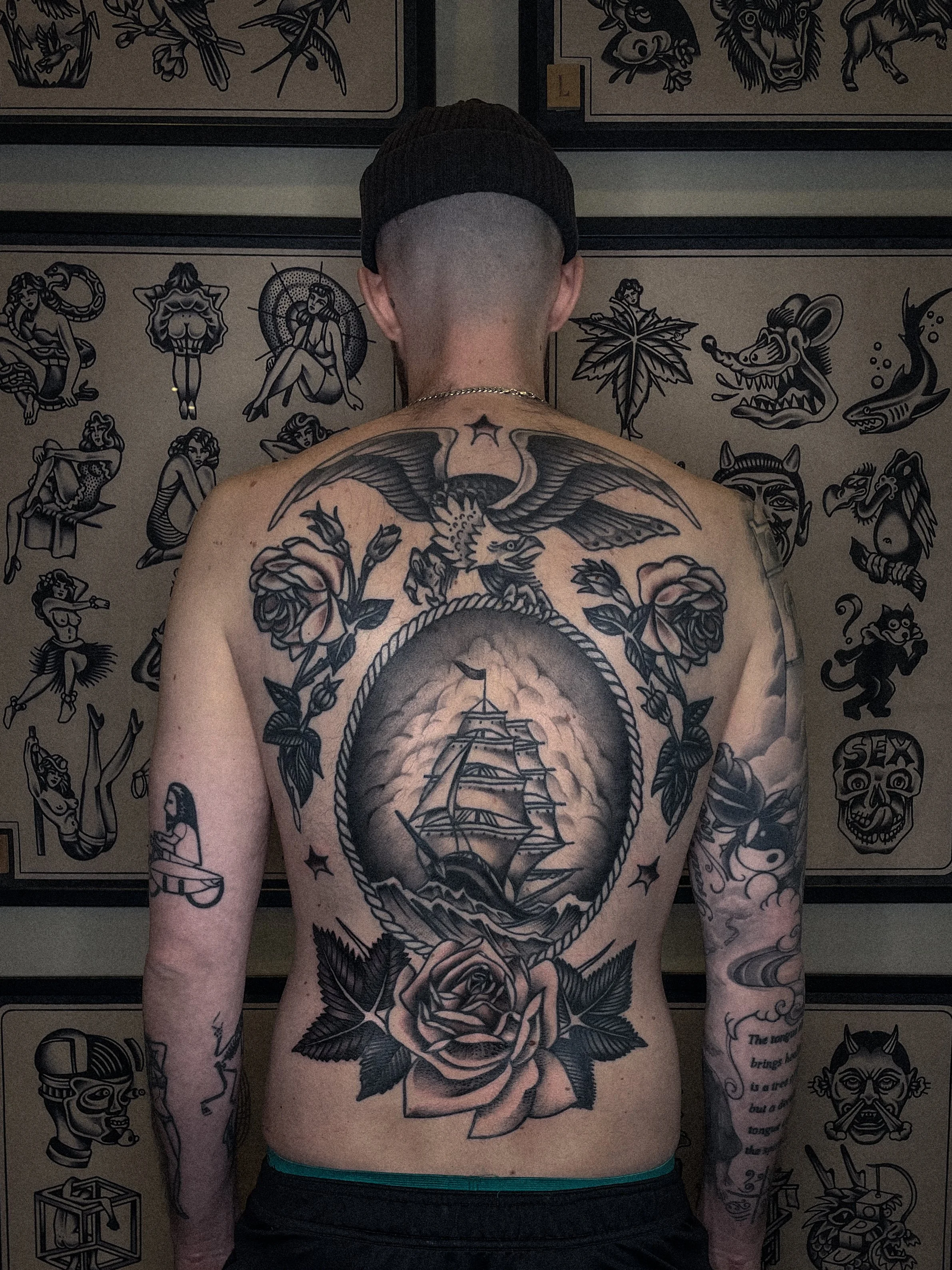 skepp örn och blommor som ryggtavla tatuering i traditionell old school stil