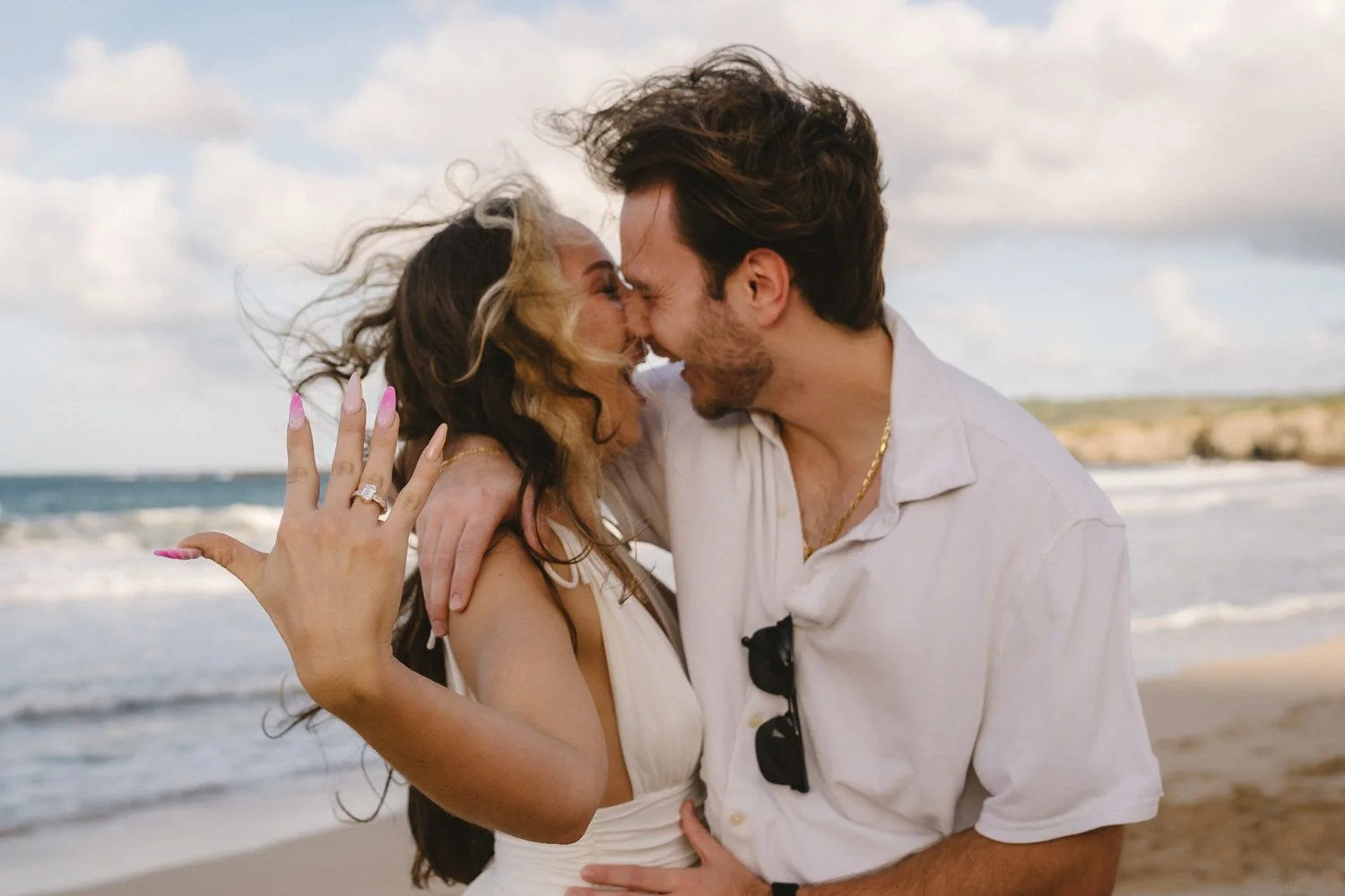 Couple showing off the ring after a surprise proposal at Ironwoods beach on Maui.