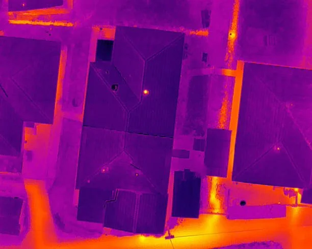 Aerial thermal view of buildings with rooftops in purple and orange hues.
