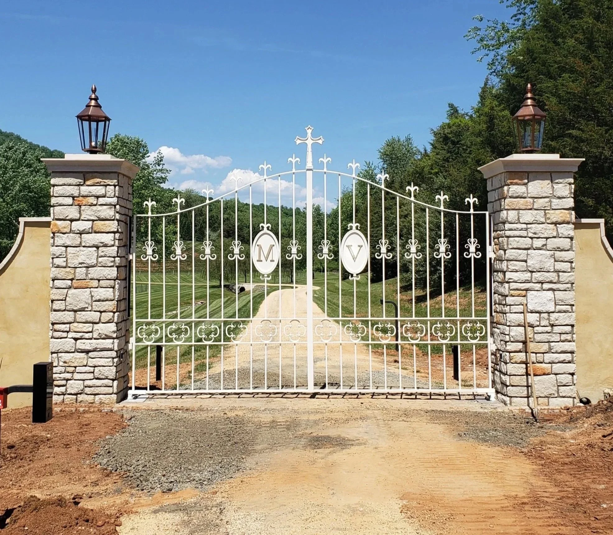 White ornamental driveway gate with electronic opening panel designed and installed by the Stokes of England Blacksmiths
