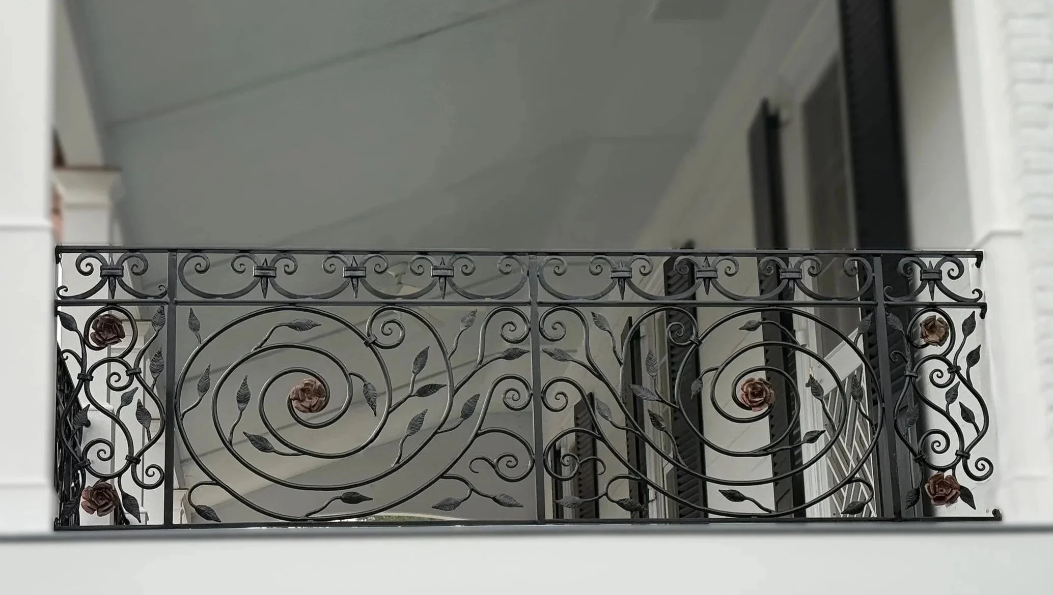 Image of an ornamental balcony railing with flowers created by Stokes of England Blacksmiths