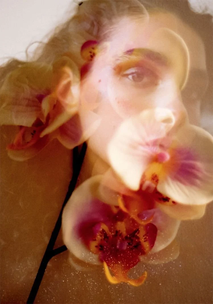 A double exposure or overlay image of a woman with flowers, creating a layered visual effect.