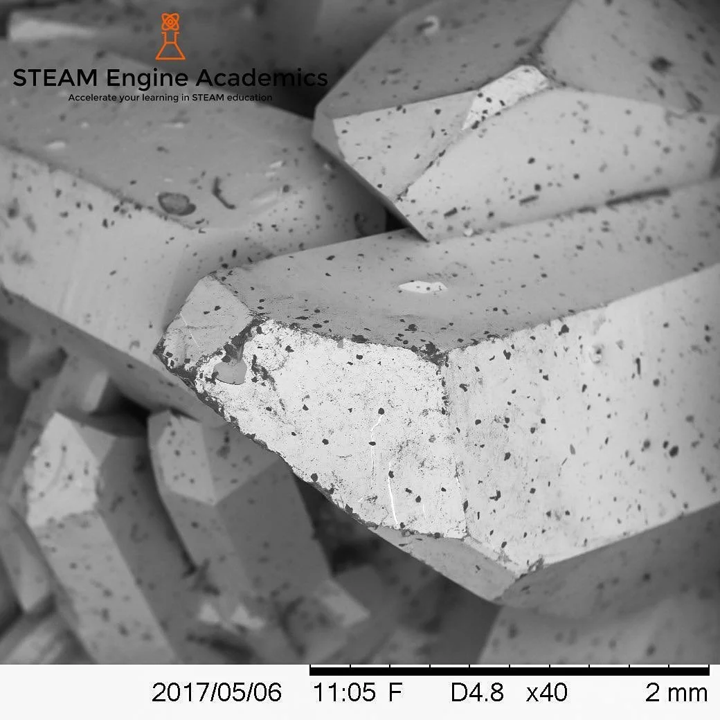 SEM (Scanning Electron Microscopy) image of sputtered titanium [Ti] onto natural quartz crystal [SiO_2]. Also known in the jewelry industry as aura quartz crystals.

#STEAM_Engine_Academics #STEAM #STEM #education #science #technology #engineering #a