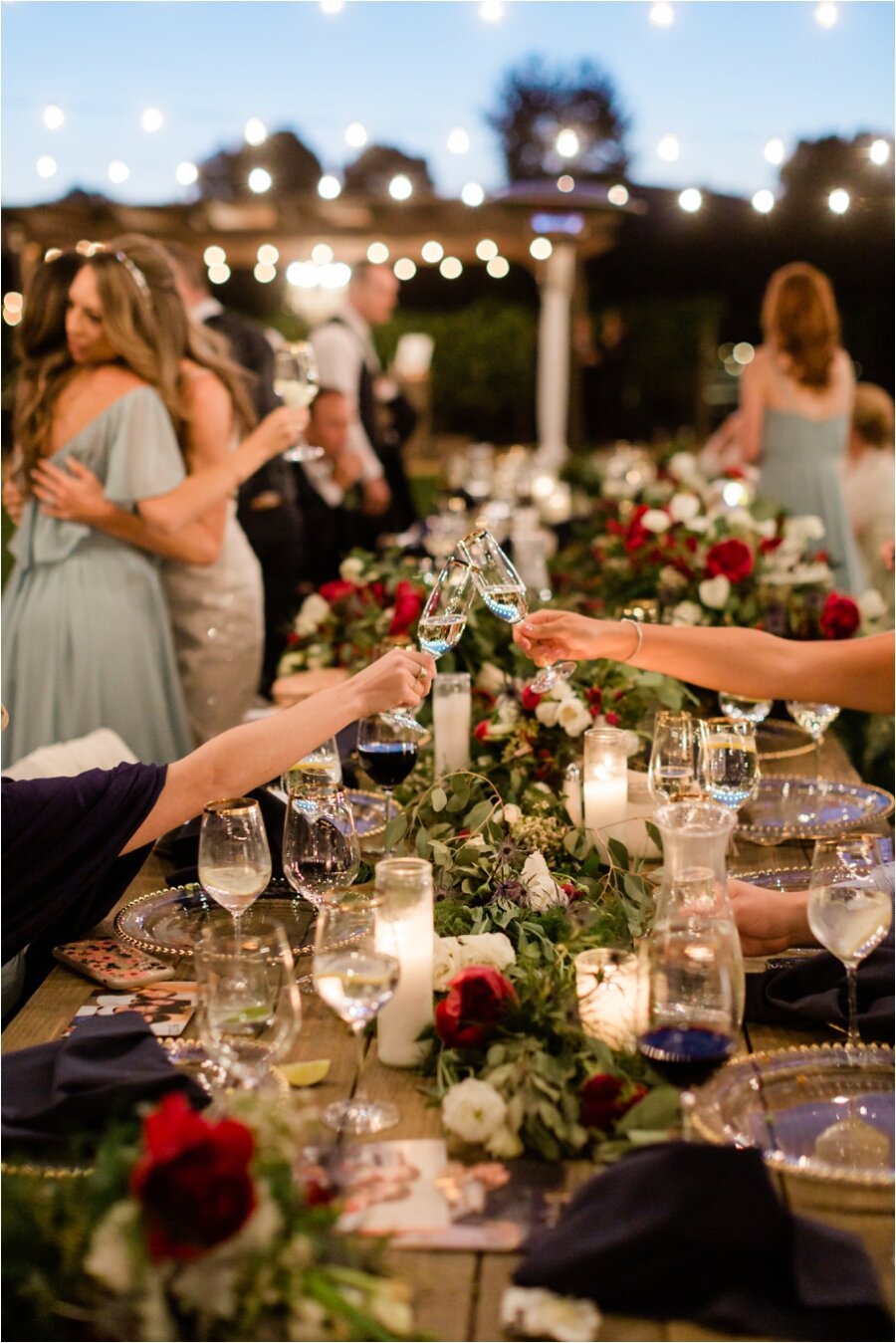 guests cheers across and long table at wedding reception