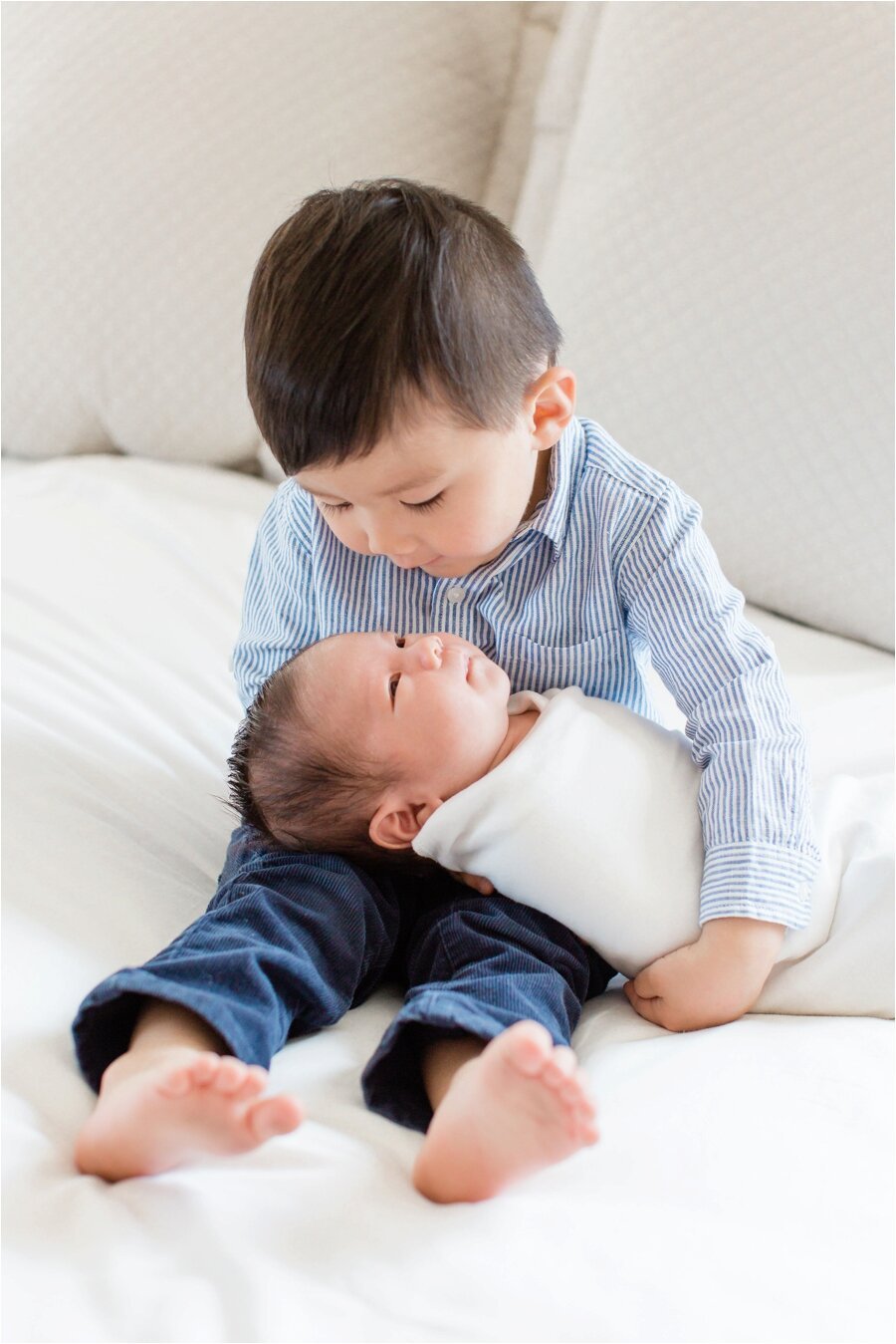 big brother poses with newborn baby brother