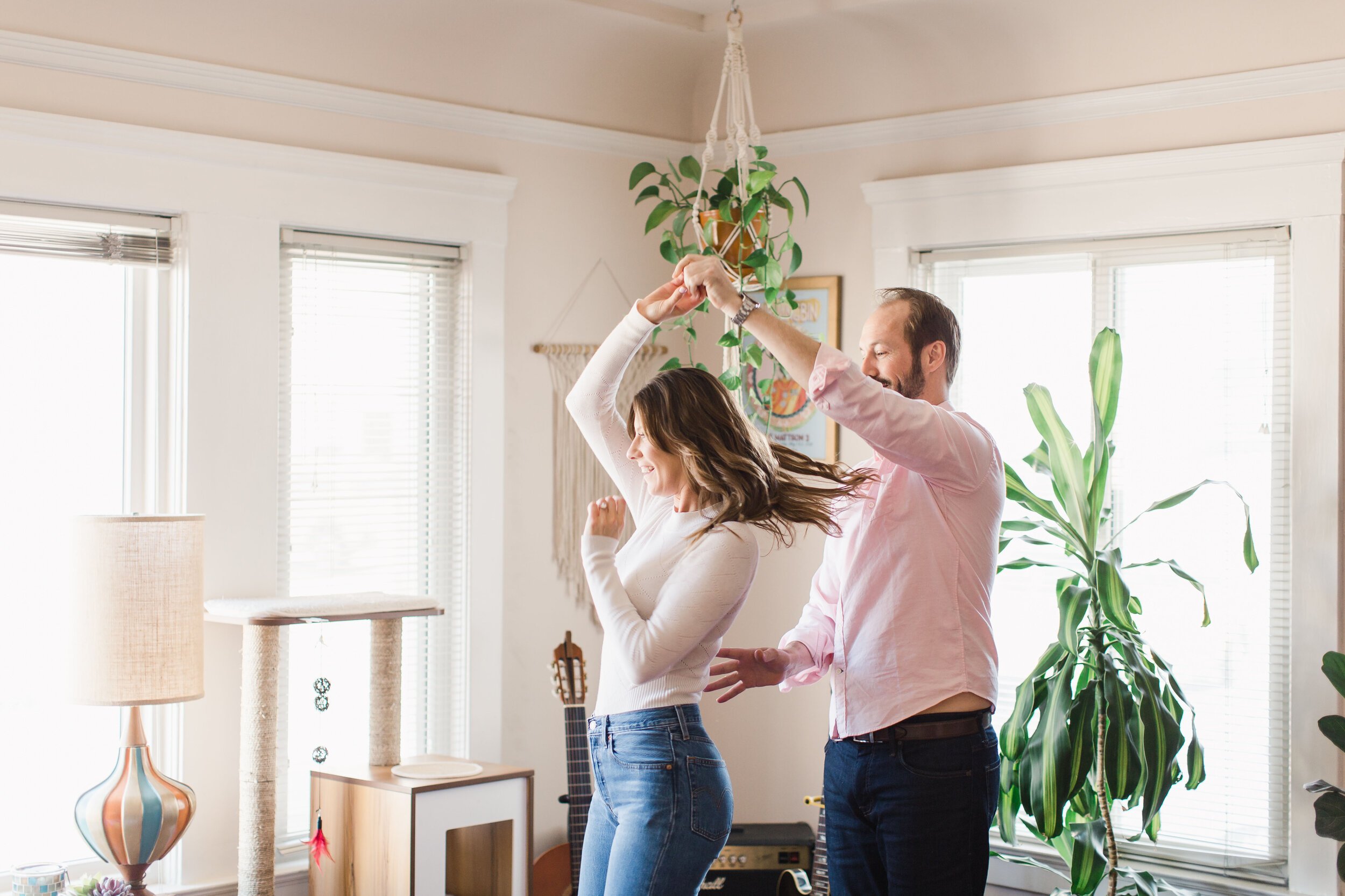 Couple dances in their living room for Engagement Session