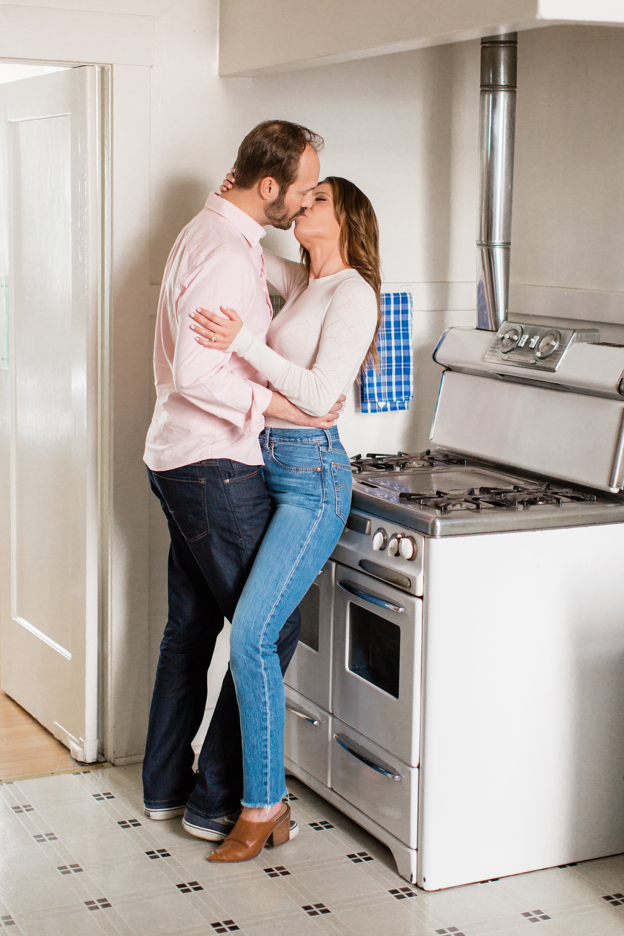 Couples kisses in their kitchen for Engagement Session