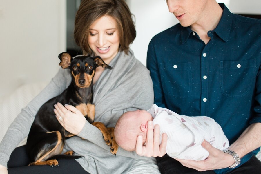 Family poses with newborn and dog