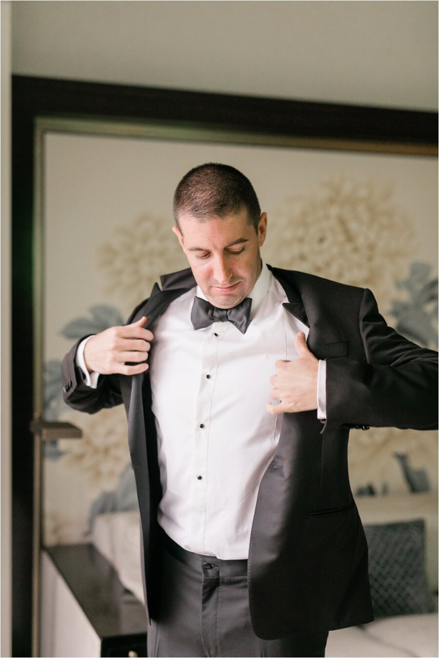 Groom puts on his jacket in his hotel room at The Peninsula Chicago