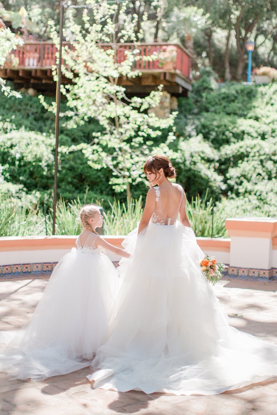 bride and flower girl holding hands