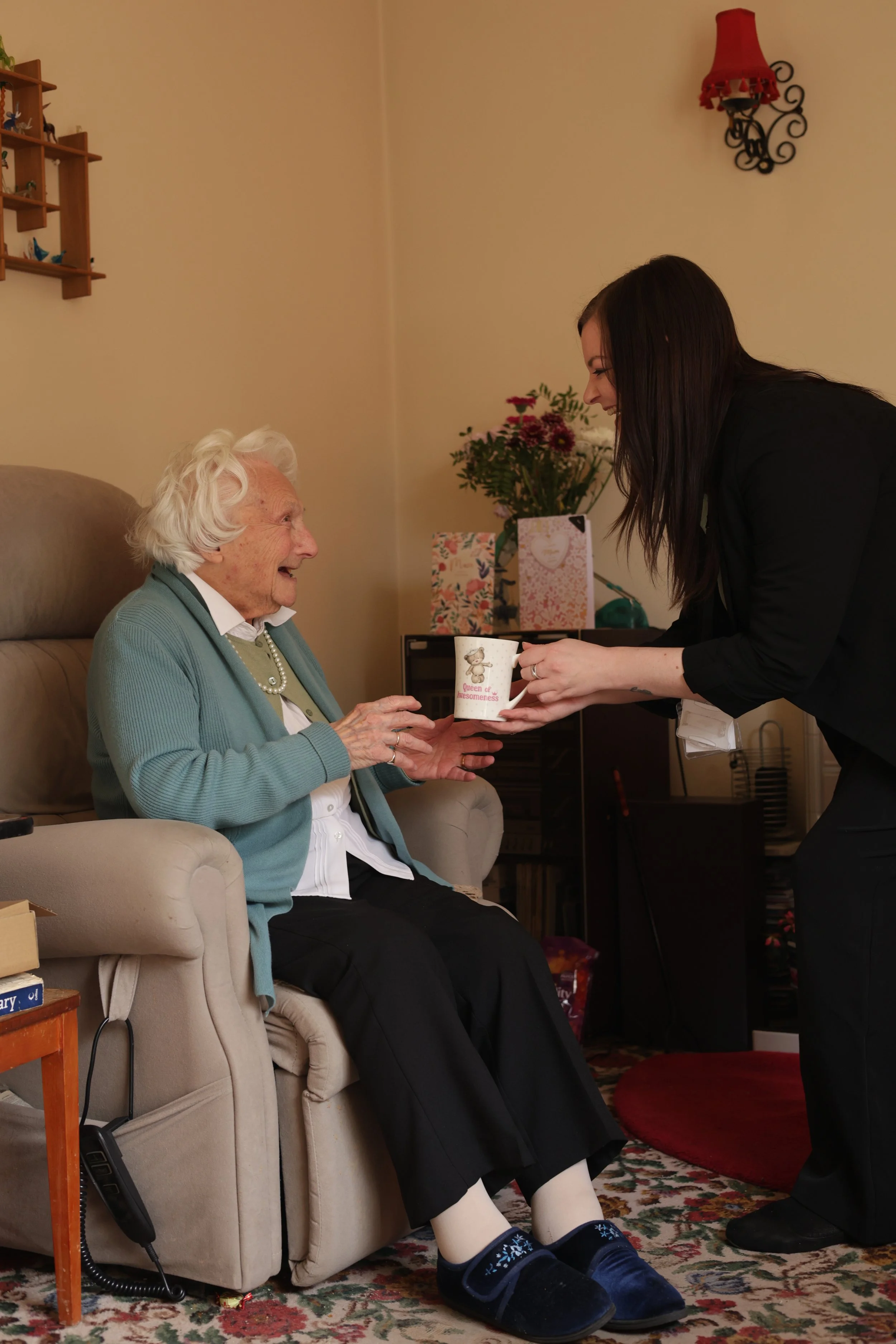 Lady on chair with cup of tea and worker