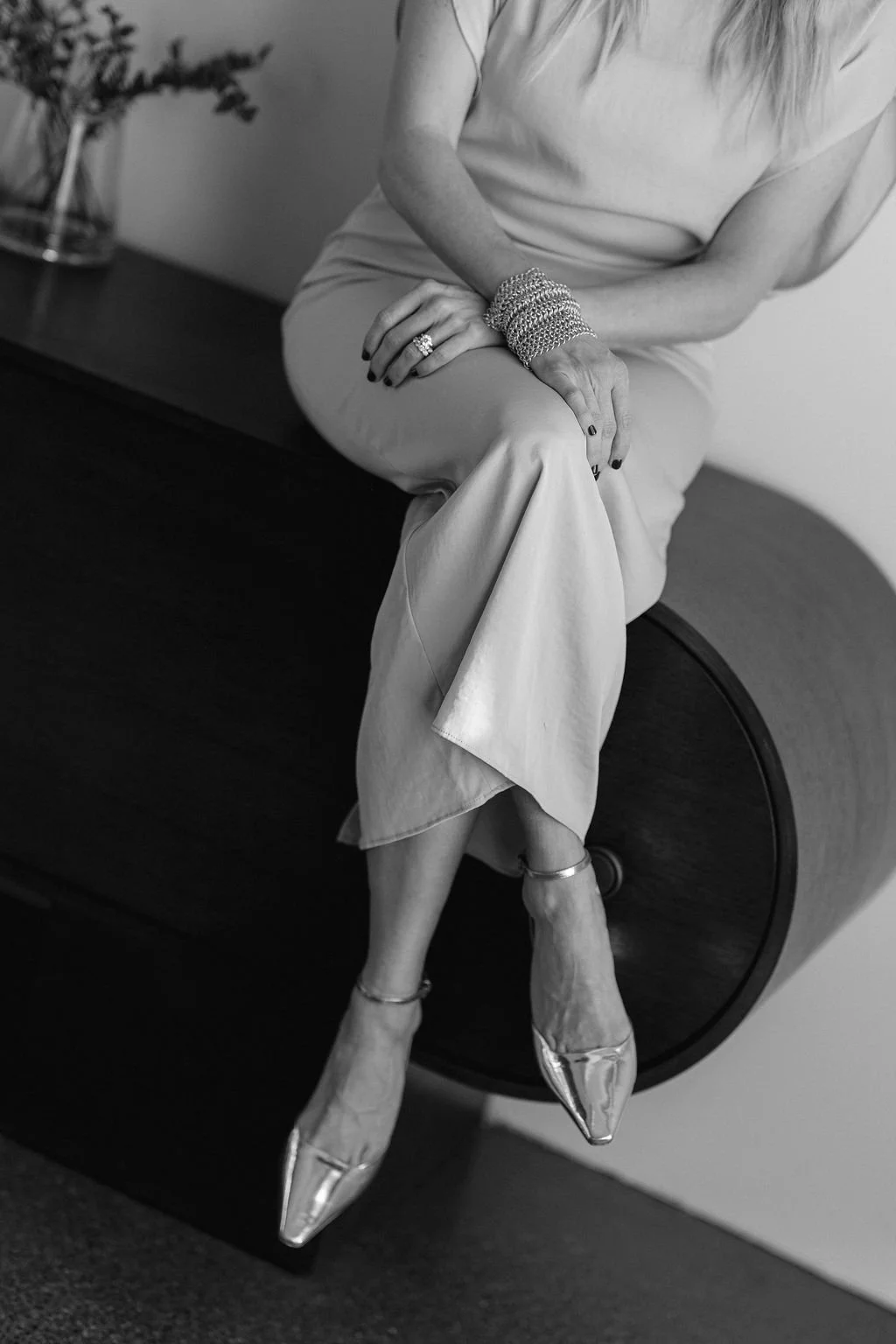 Kathryn Snow, personal stylist, fashion expert, and wardrobe consultant in Grand Rapids, Michigan dressed in elegant attire, sitting on a piece of furniture, with her legs crossed.