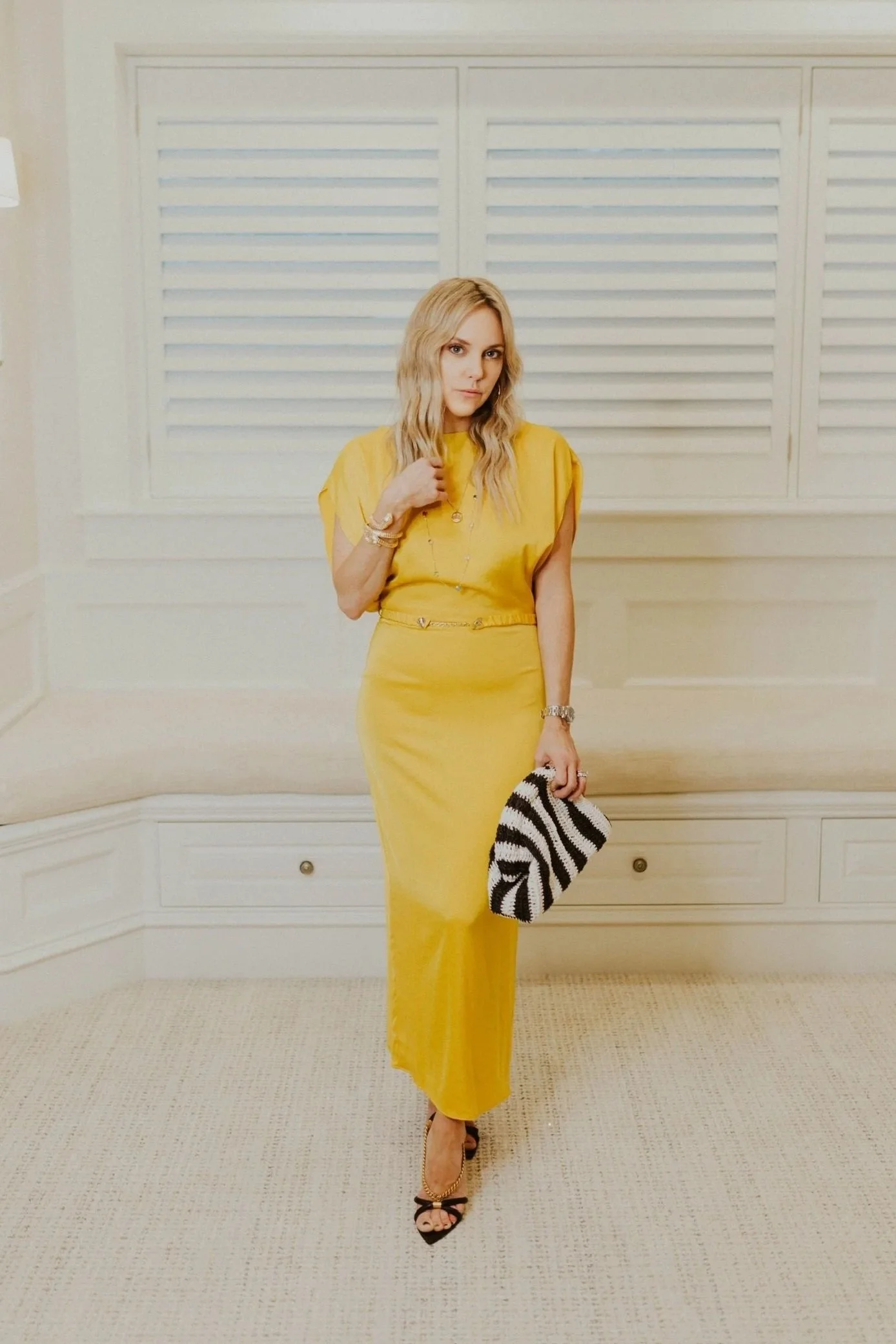 Kathryn Snow, personal stylist, fashion expert, and wardrobe consultant in Grand Rapids, Michigan, holding a black and white striped clutch bag. This image was originally for West Michigan Woman editorial.
