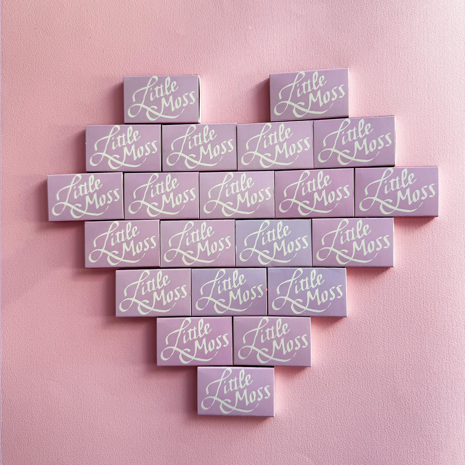 a Heart shape assembled from lavender colored matchbooks that all say 'Little Moss" in white calligraphic writing