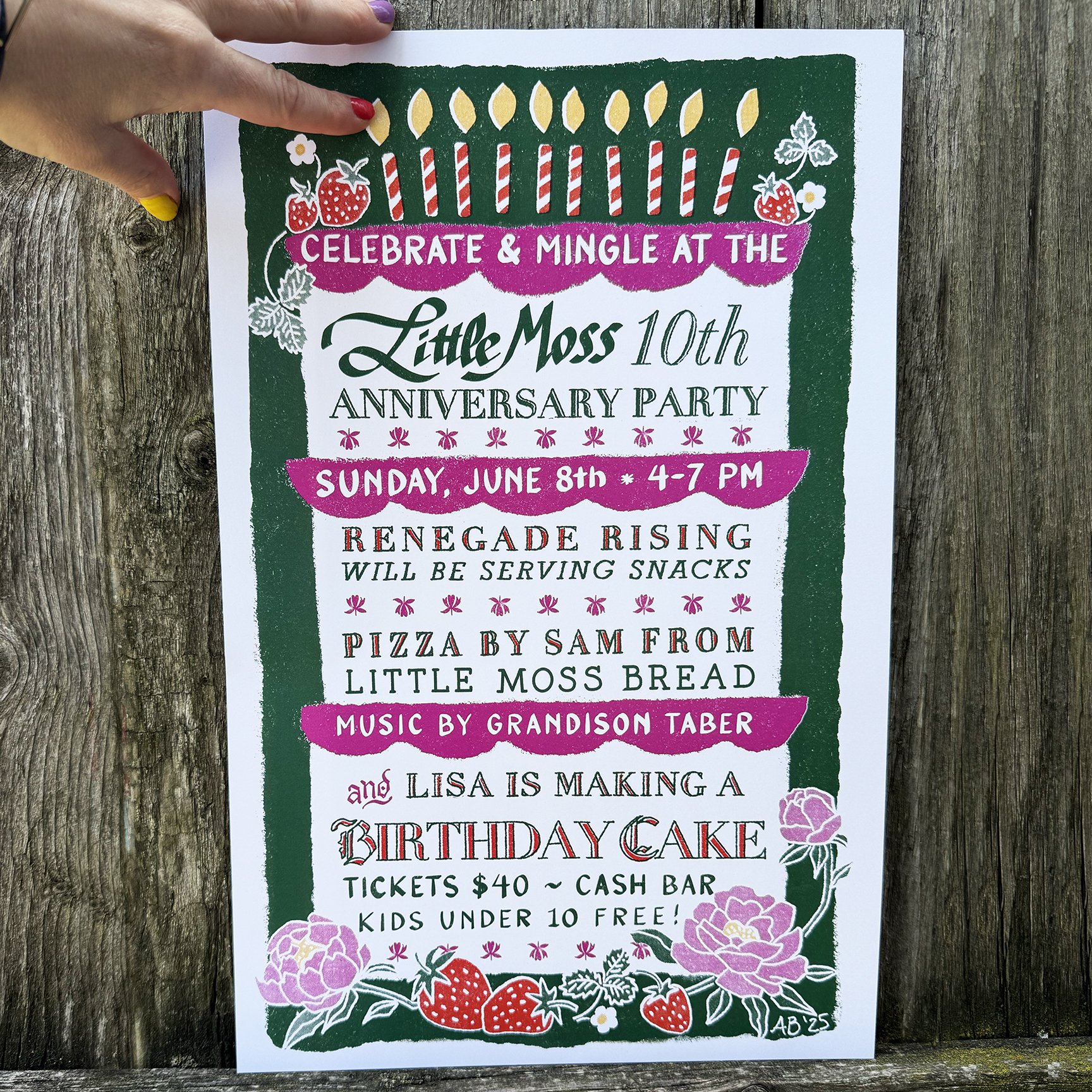 A hand holding a printed poster of a birthday cake for the 10th birthday of Little moss Restaurant