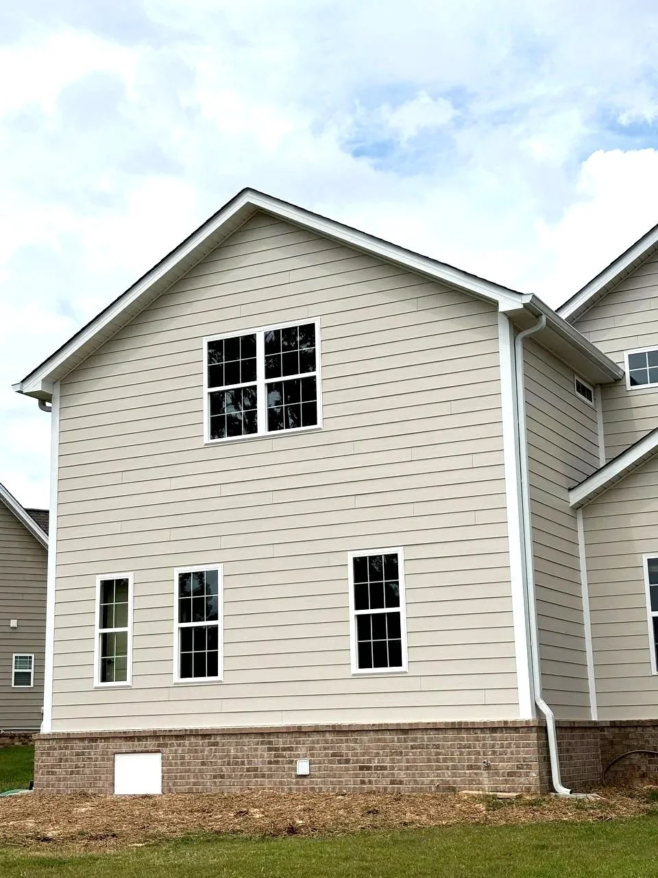 Exterior view of custom two-story home addition in Chattanooga TN with matching siding and brickwork.