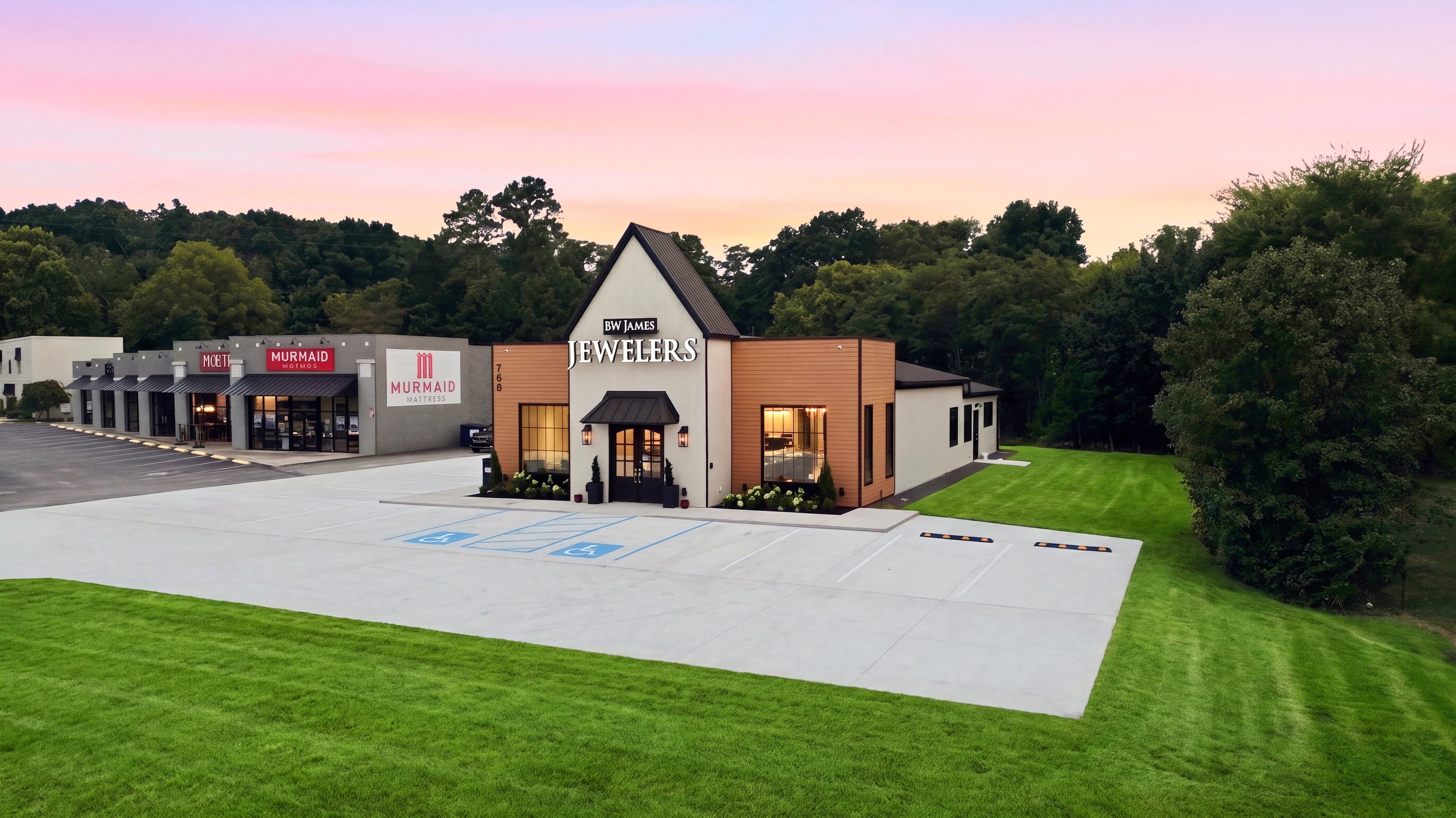 Exterior view of BW James Jewelers in Cleveland, TN, featuring a custom-designed storefront, prominent signage, landscaped entrance, and a spacious concrete parking lot with accessible parking.
