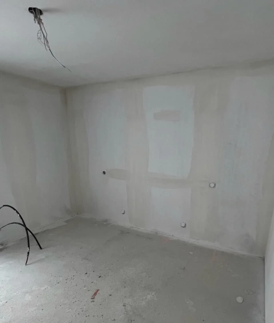 Aménagement d’une chambre d’appartement témoin à Vannes, intégrant un espace de rangement optimisé et un travail de peinture pour créer une ambiance douce et fonctionnelle, facilitant la projection des acquéreurs.