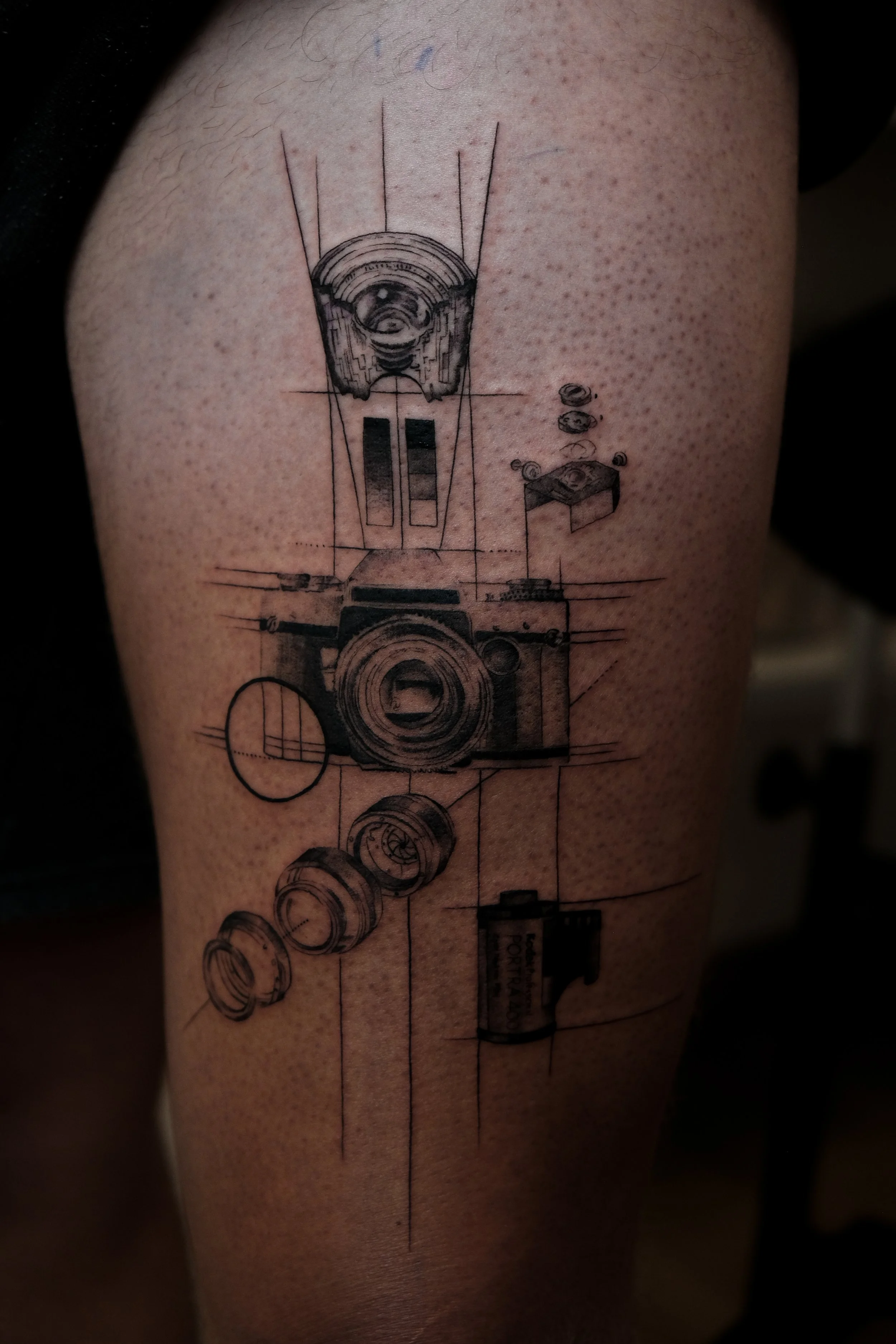 Tattoo eines technischen Skizzen-Designs eines Kameras mit Einzelteile und Linien.