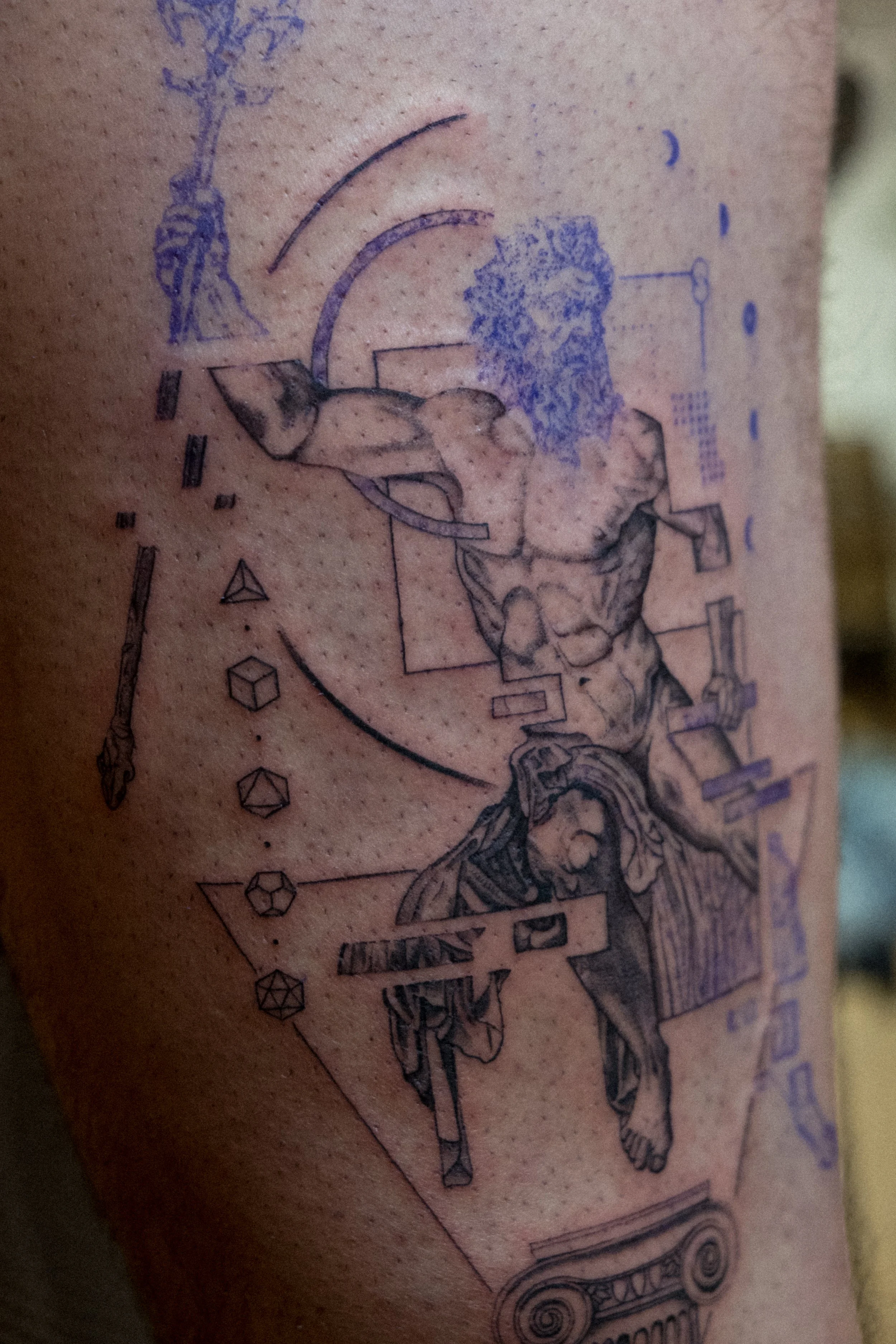 Tattoo mit einer anatomischen Studie eines menschlichen Körpers, geometrischen Formen und technischen Zeichnungen.