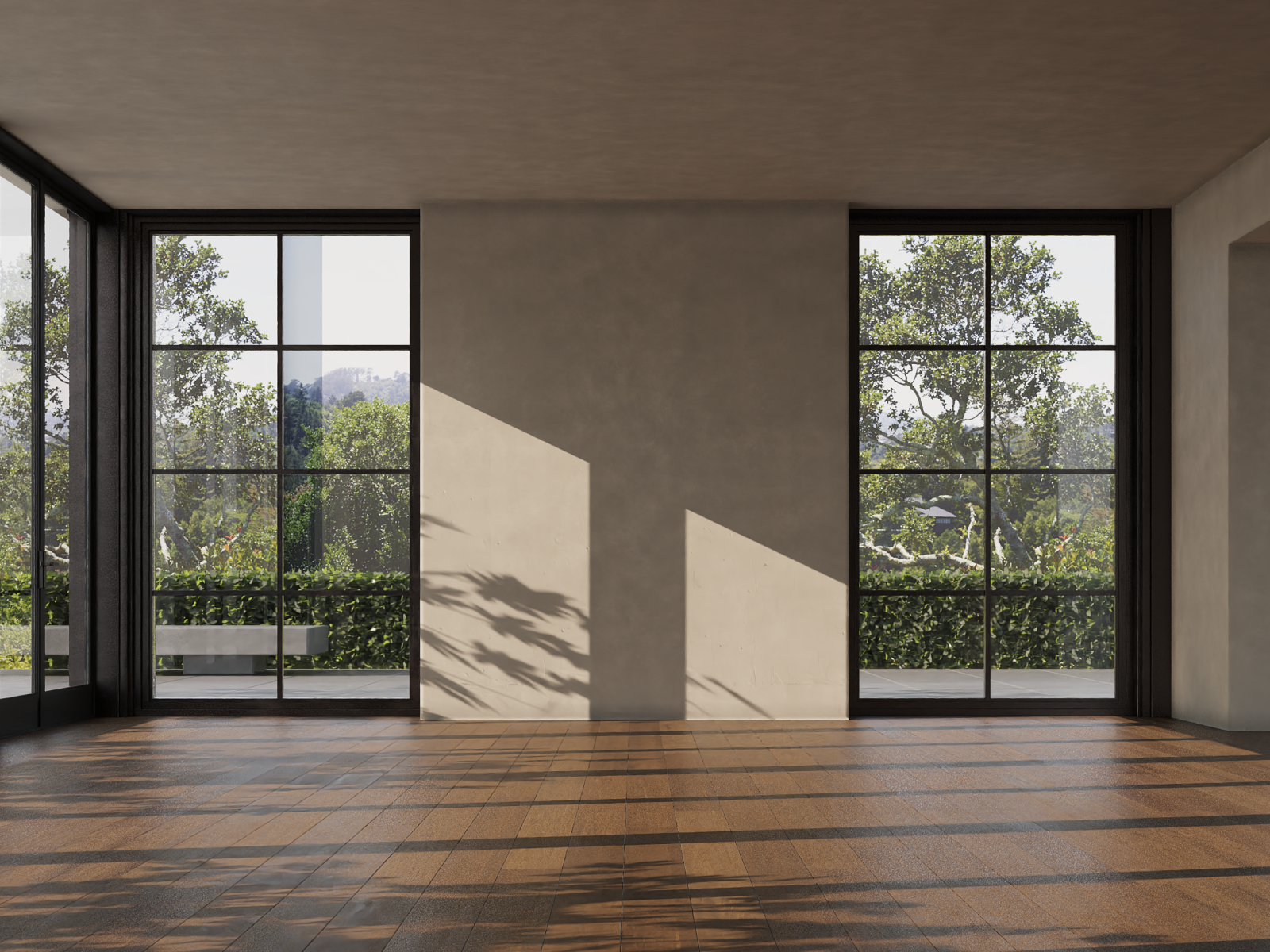 Empty room with large black framed windows showing trees and outdoor greenery, sunlight casting shadows on beige wall.