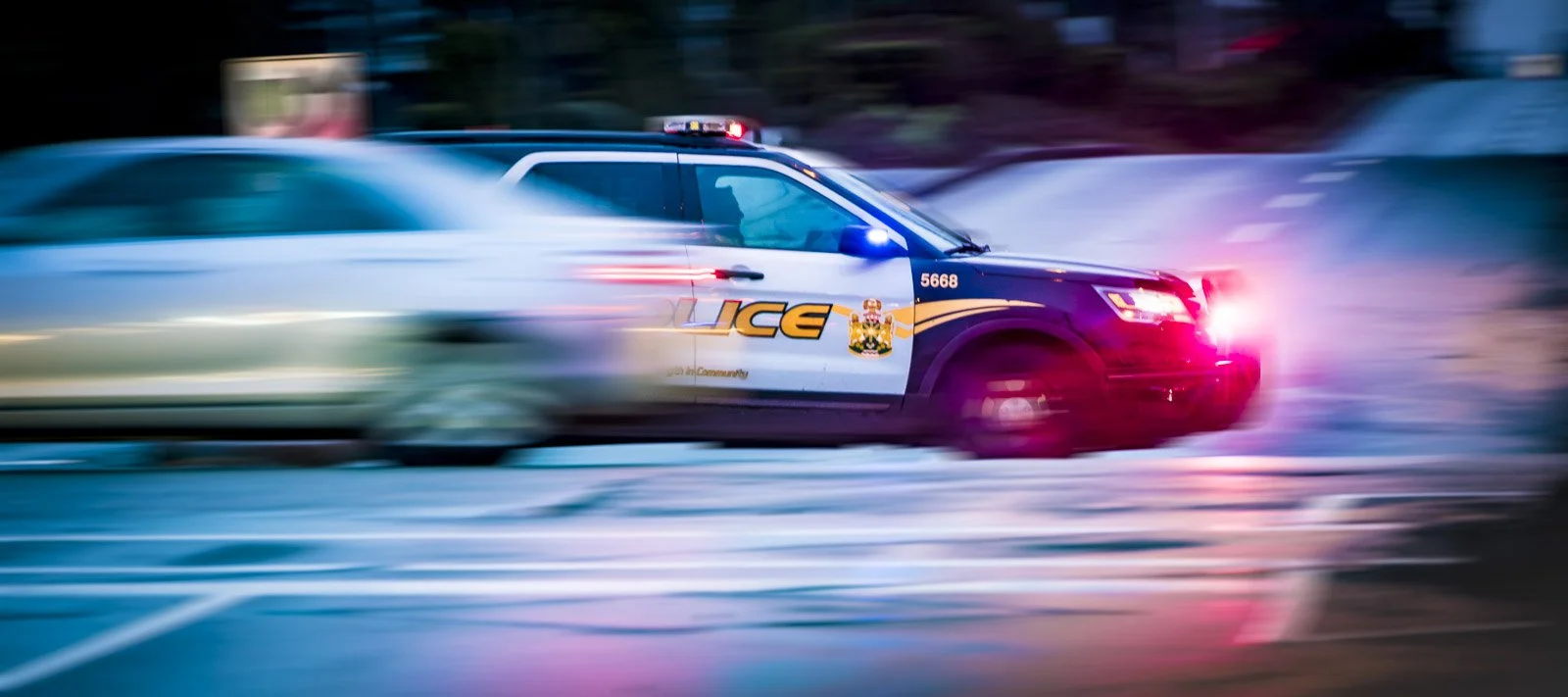 Moving police car with flashing lights in pursuit, motion blur, night scene