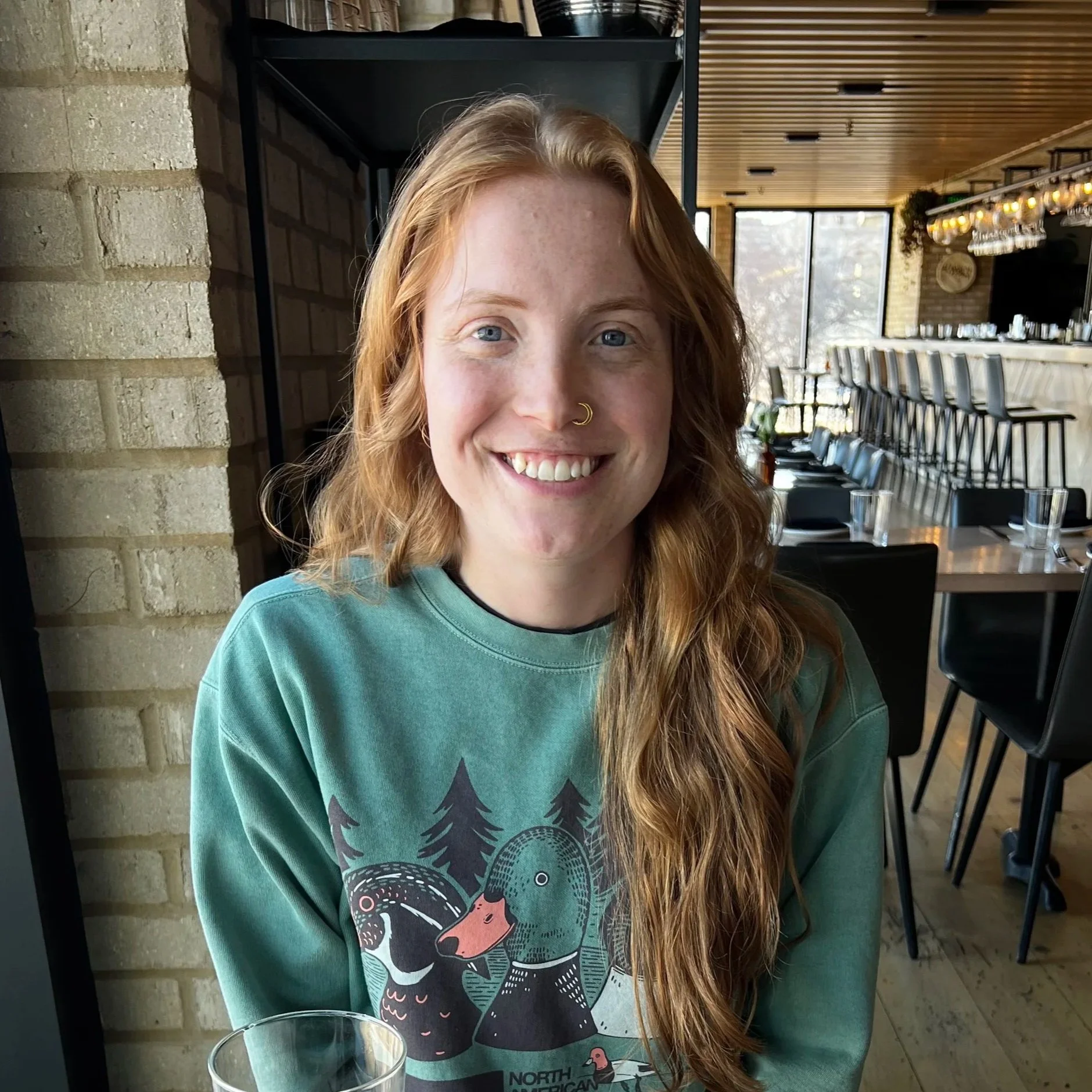 a headshot of a white person with long red hair smiling