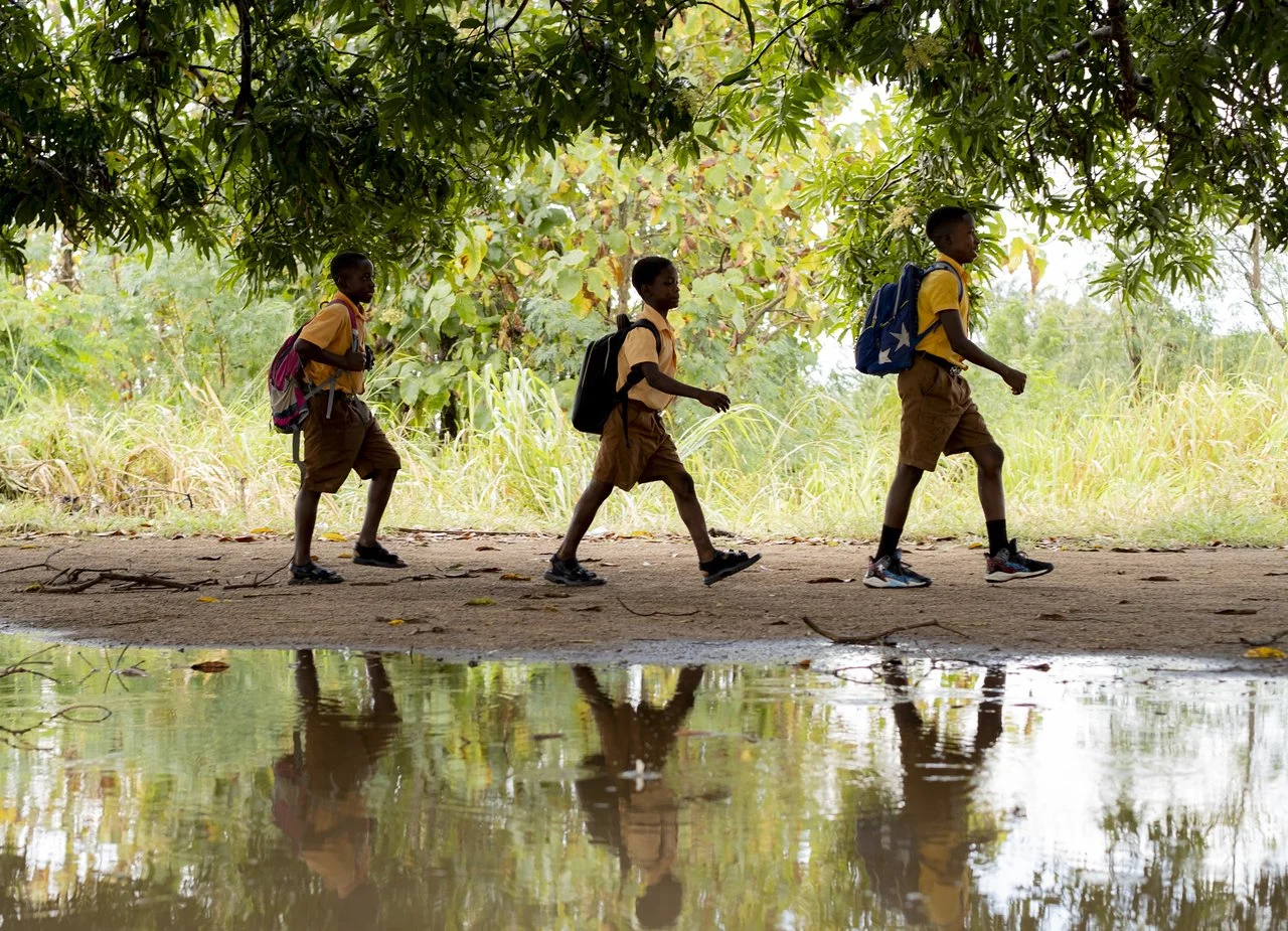 image of three ghana school boys walking with their backpacks on