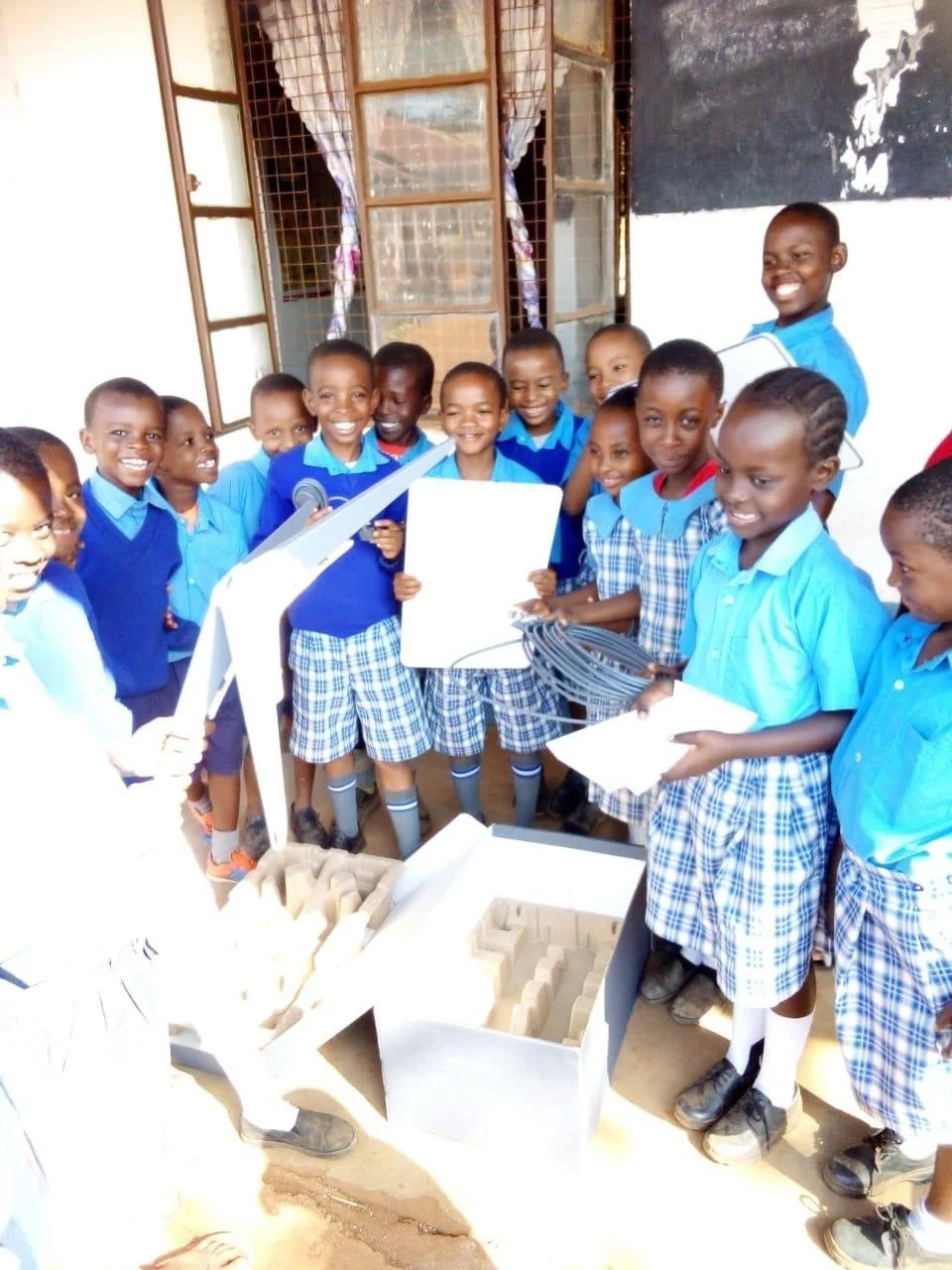 a group of happy children holding a starlink and smiling