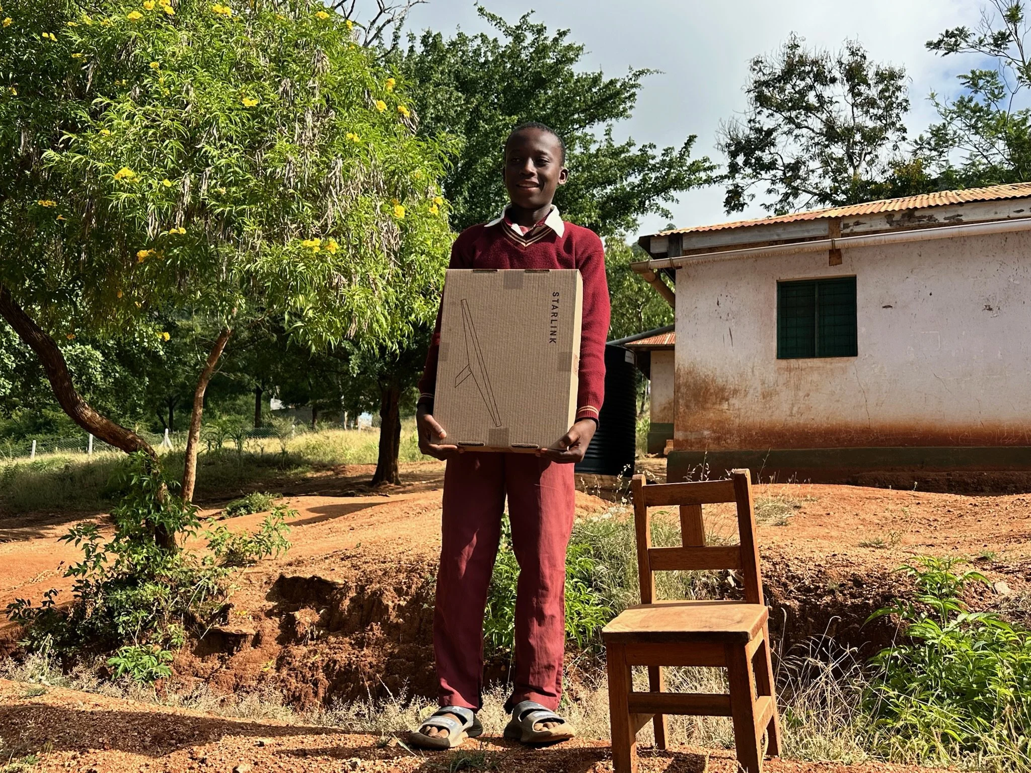 a young boy holding a starlink box and smiling