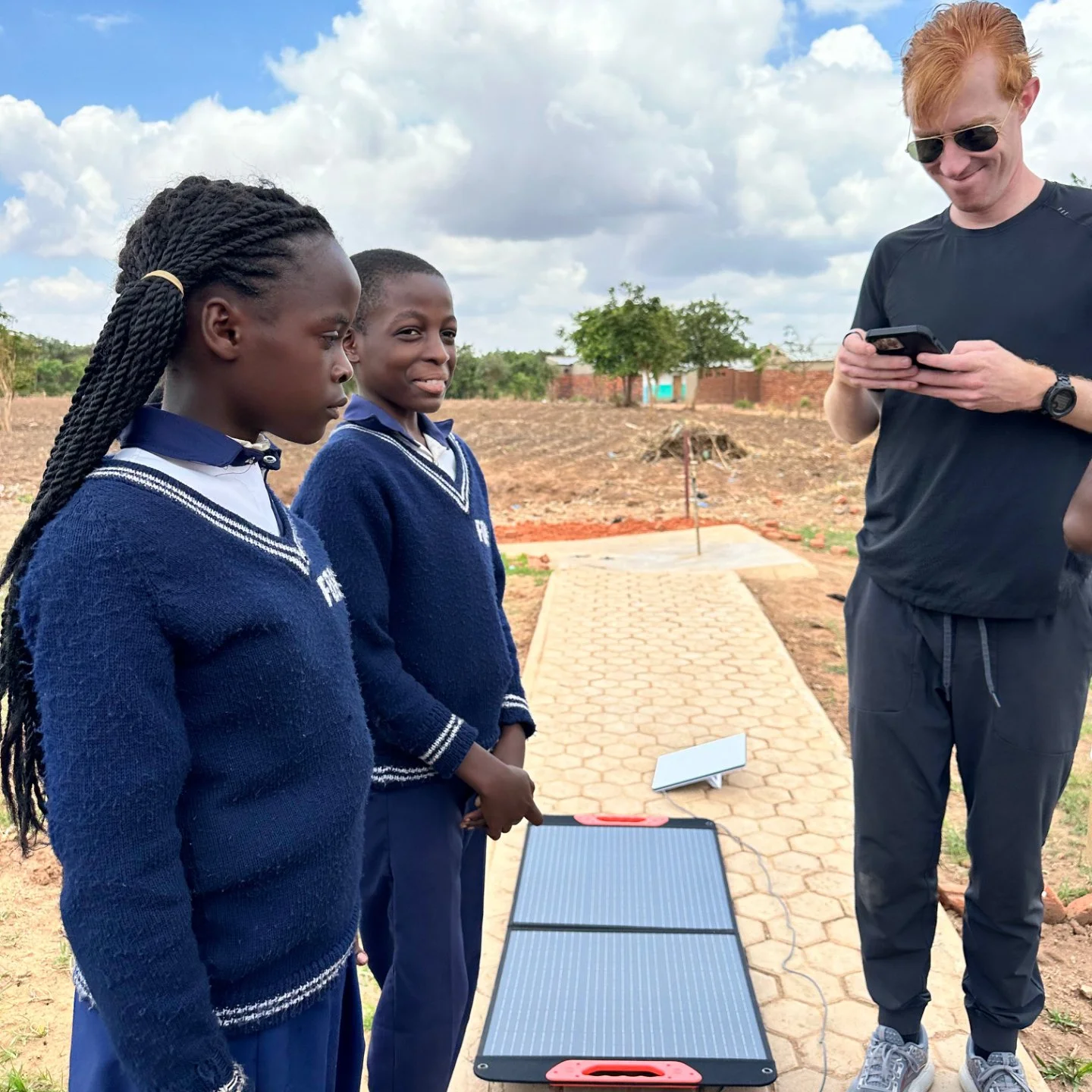 two young african students helping set up a starlink