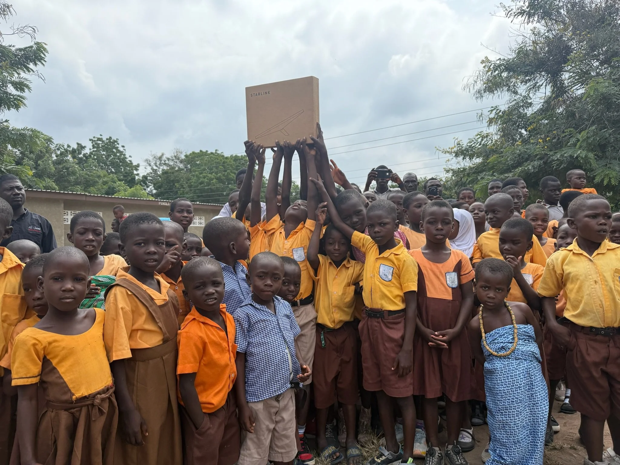 image of a large group of students in africa holding up a box