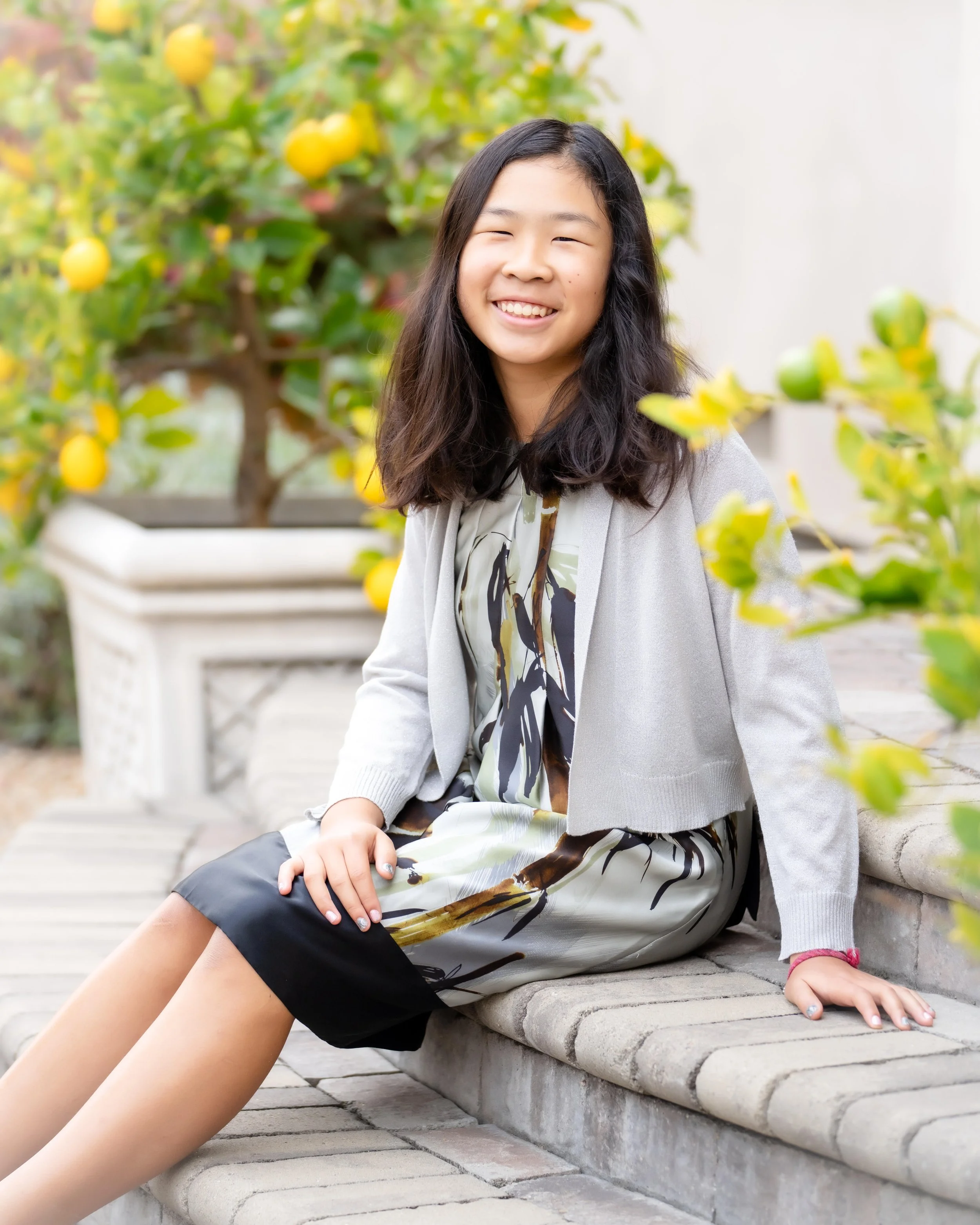 image of a young girl sitting on a step and smiling at the camera