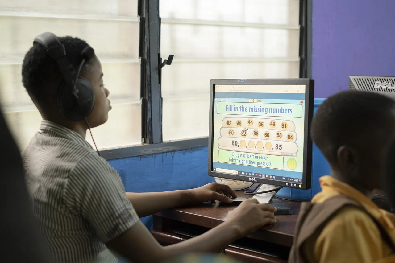 image of a young school boy in ghana using a computer to learn on the internet