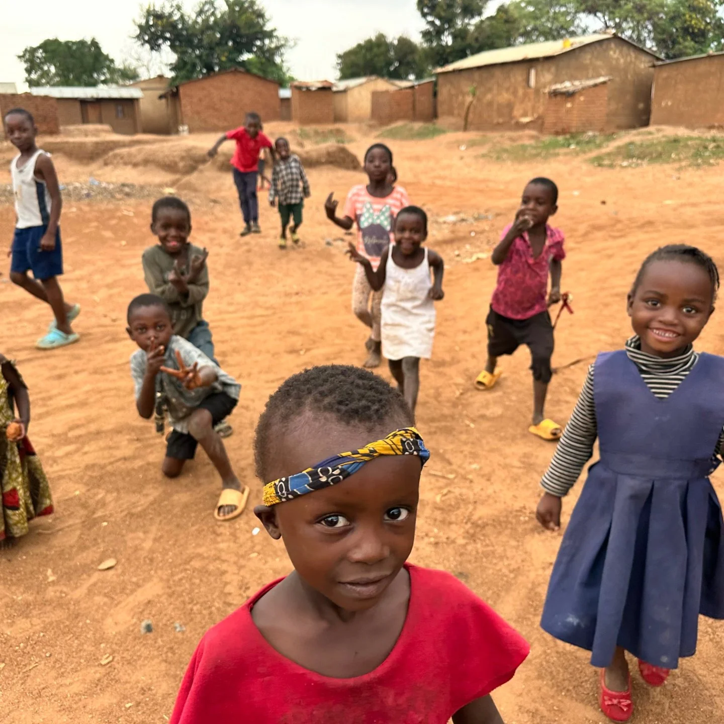 a group of young kids smiling outside in africa