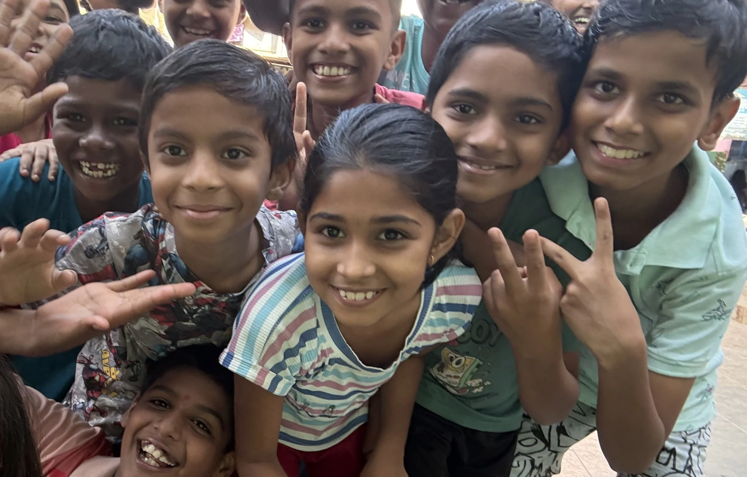 kids in india smiling at the camer and huddled together