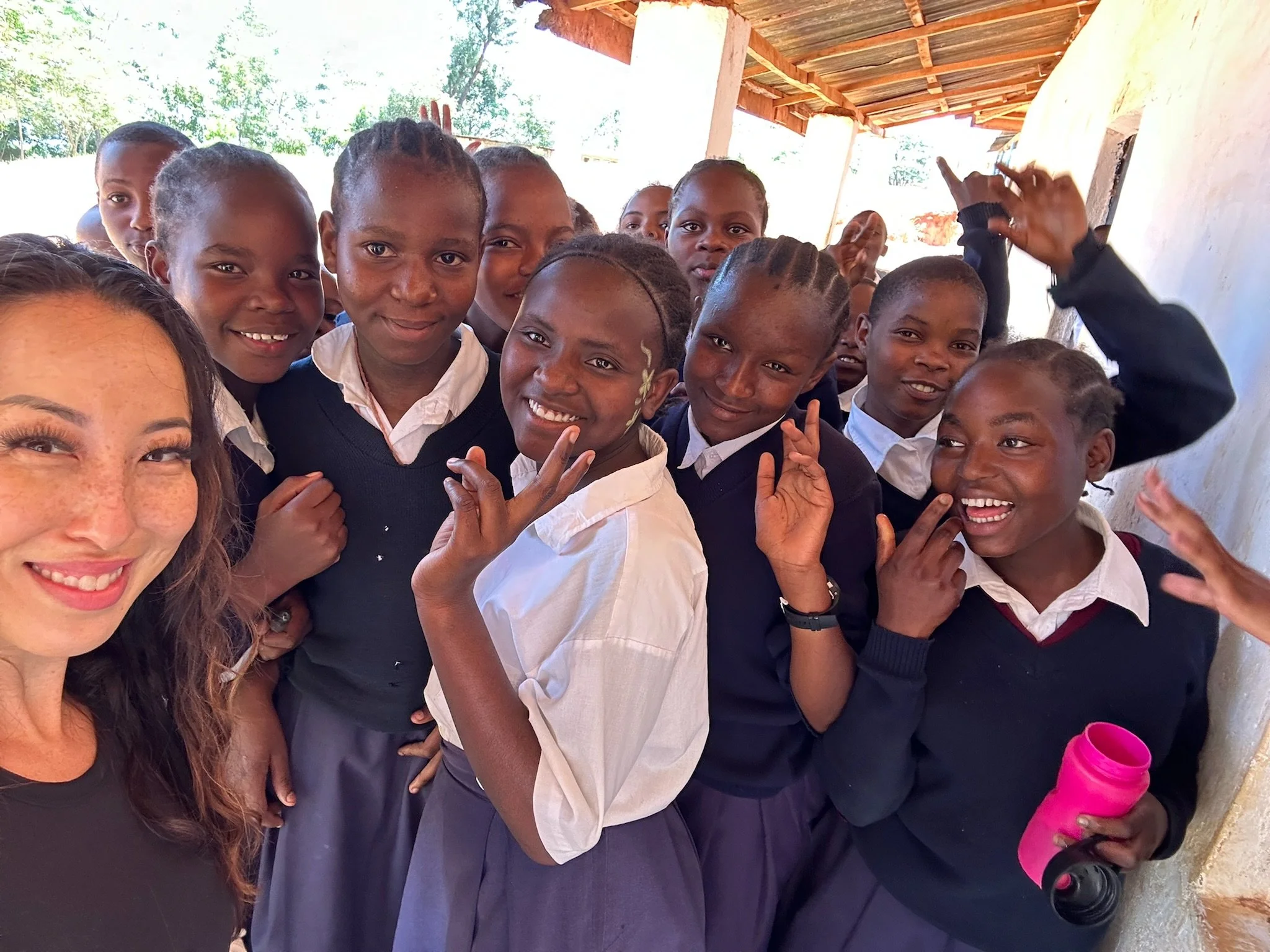 a group of young kenyan school girls smiling at the camera