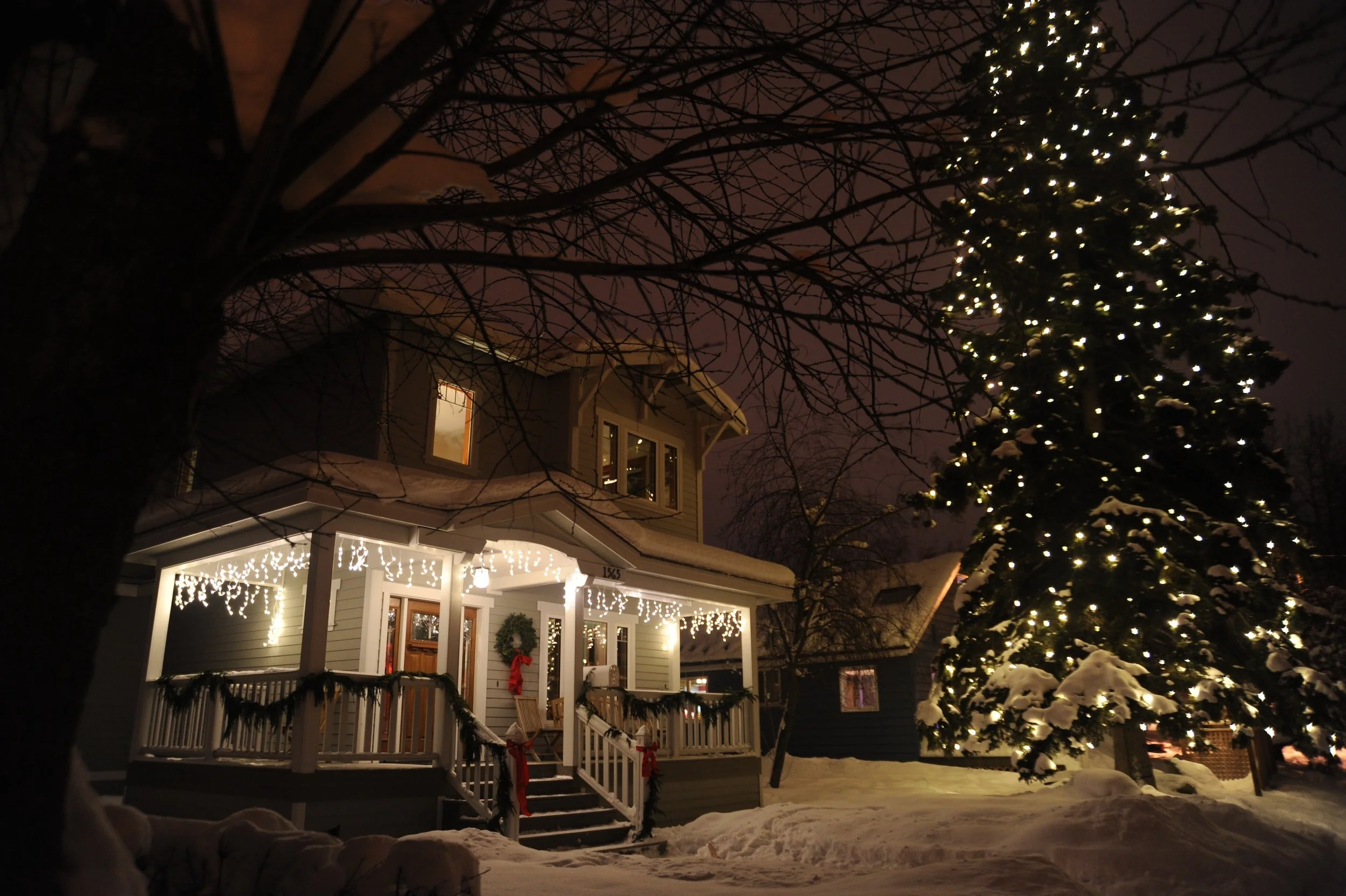 A home in snow decorated for the holidays