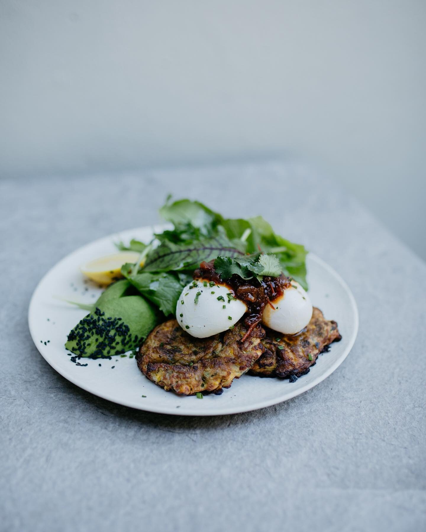 Packed full of garden herbs and the most delishaus green tomato chutney to match, try our corn fritters. Corn fritters + poached eggs + avocado + HAUS green tomato chutney + coriander + chives + dressed garden salad leaves (V). Get on it. #milkhausmi
