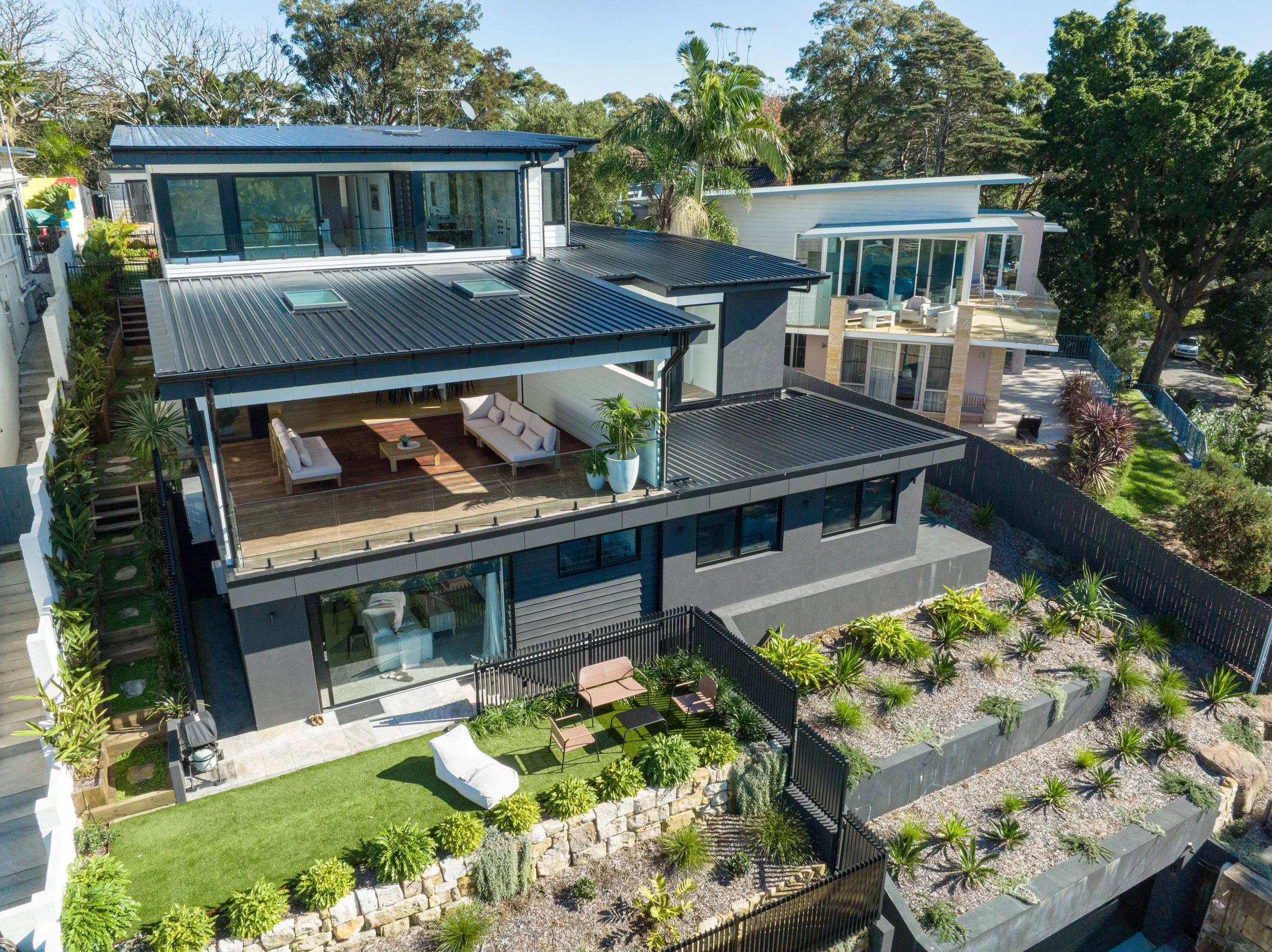 Aerial view of a contemporary home with multi-level terraced landscaping by Streamlined Build.