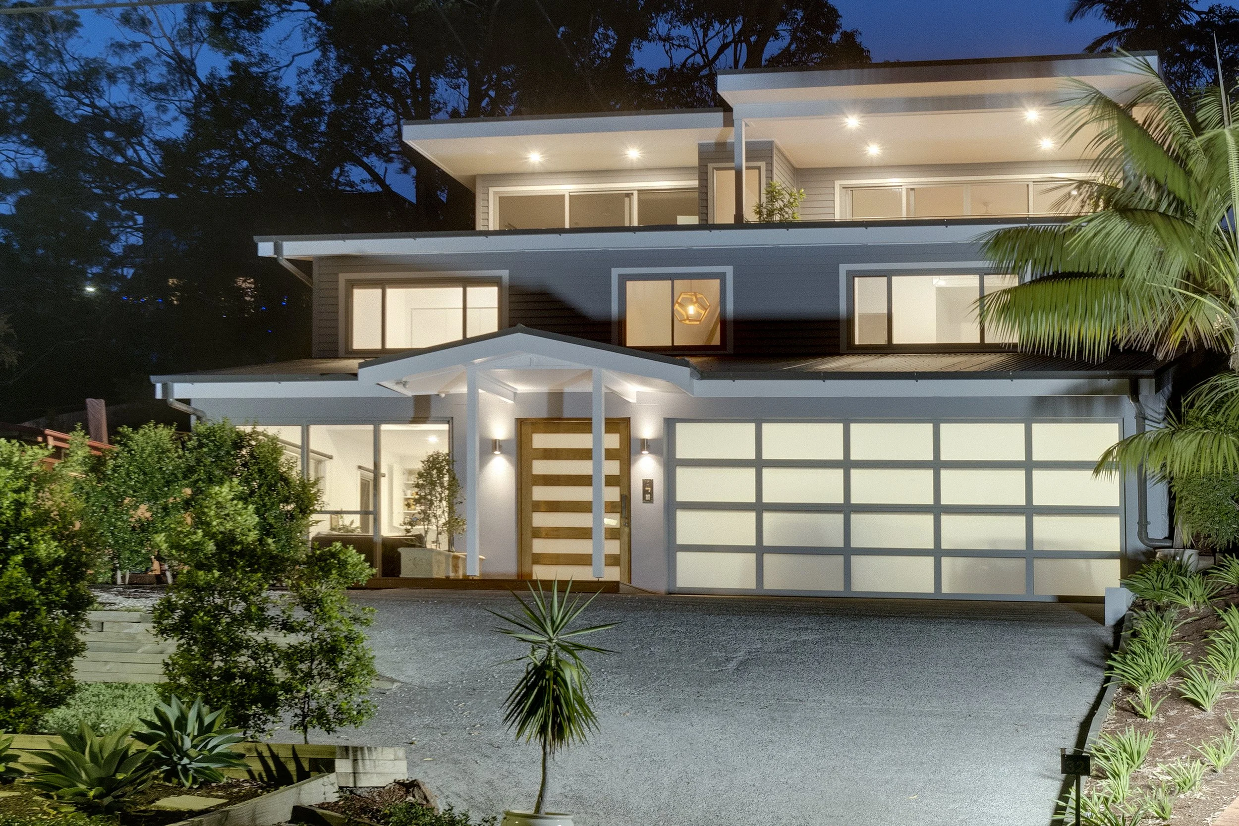 Modern two-story home exterior with illuminated garage, a Streamlined Build project.