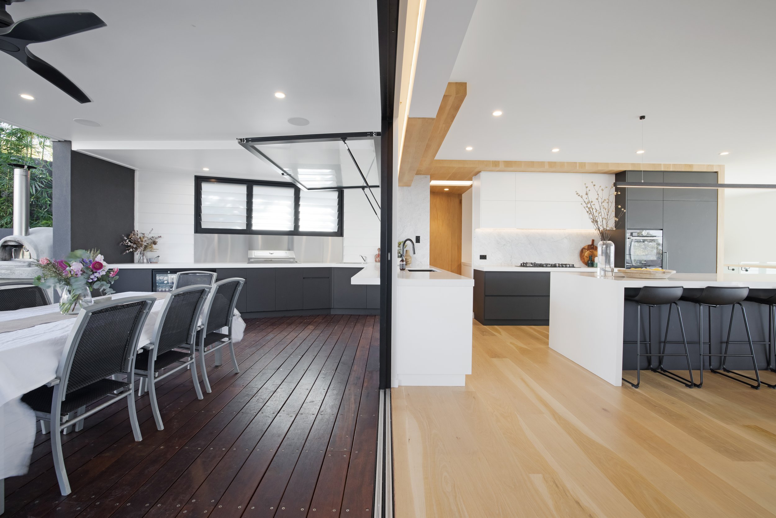 Streamlined Build design showing seamless indoor-outdoor flow between kitchen and deck.