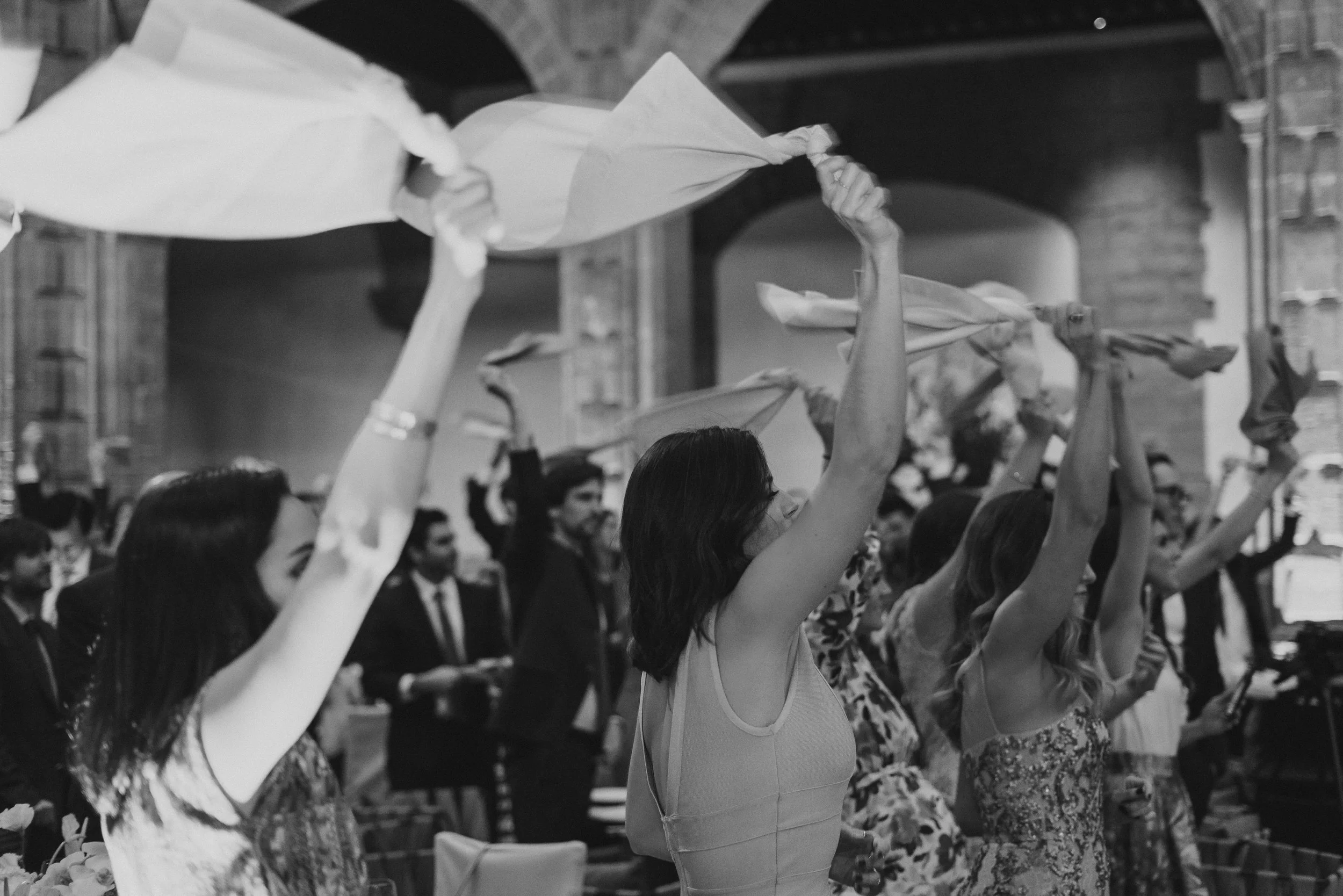 Personas levantando pañuelos en una ceremonia en un edificio de piedra.